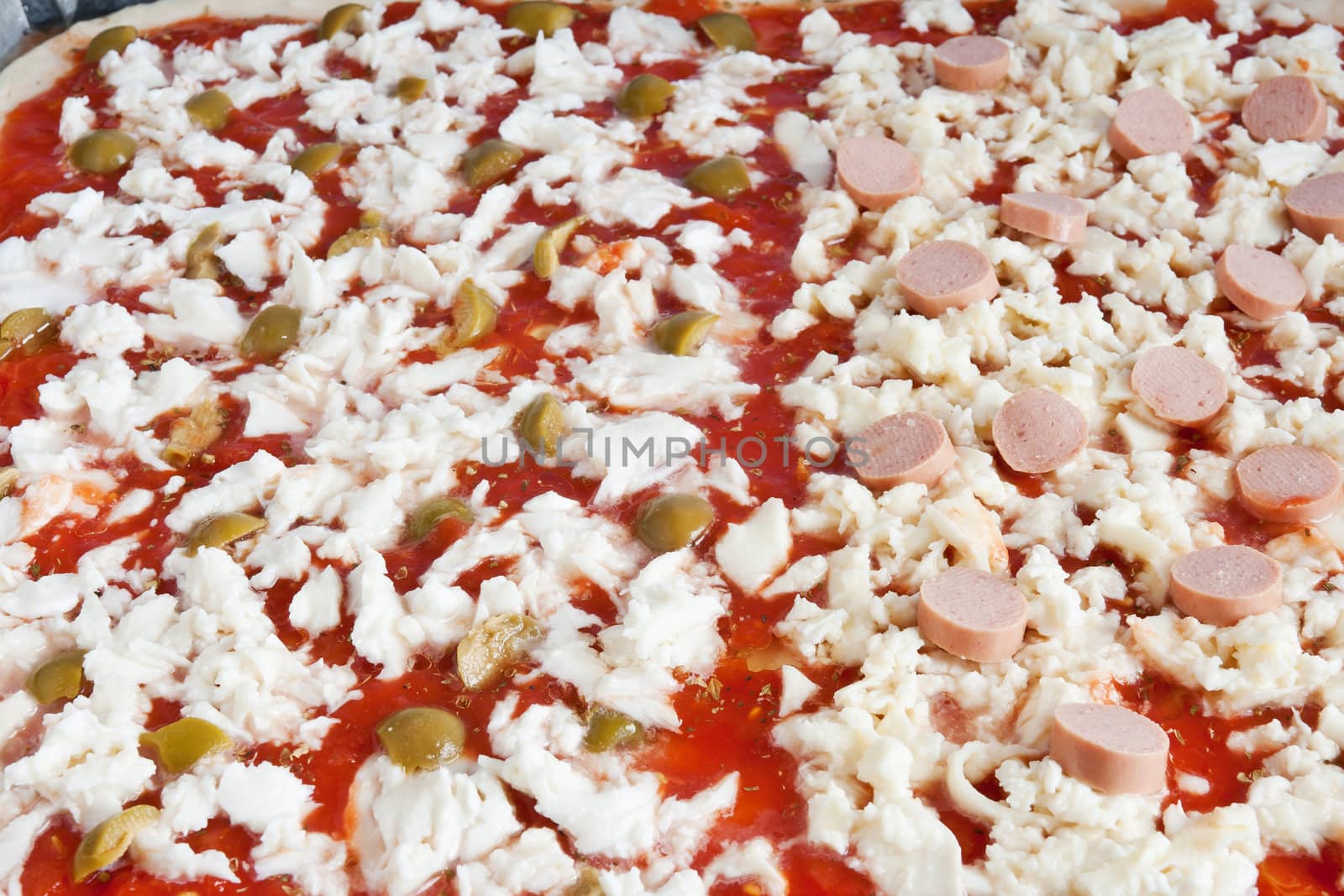detail of raw pizza with tomato mozzarella olives and wurstel