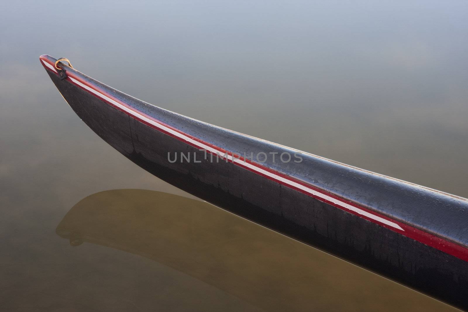 slim bow of a racing kayak (carbon fiber design) on calm lake