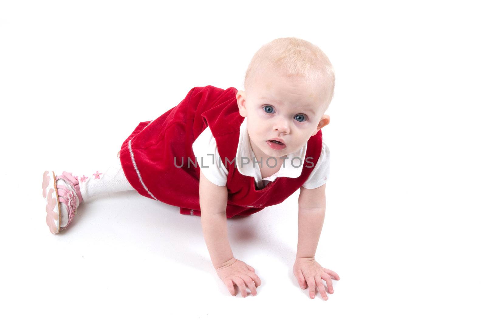 Baby in red is sitting on the floor