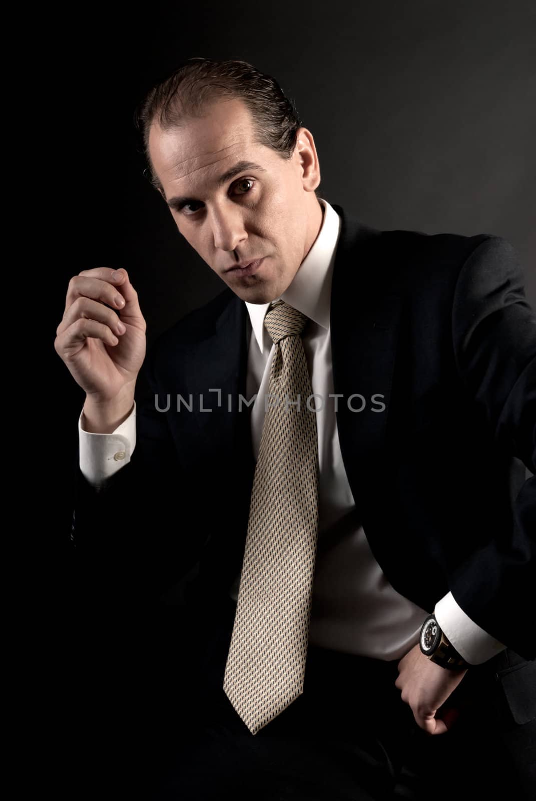 adult businessman welldressed serious sitting looking at camera.