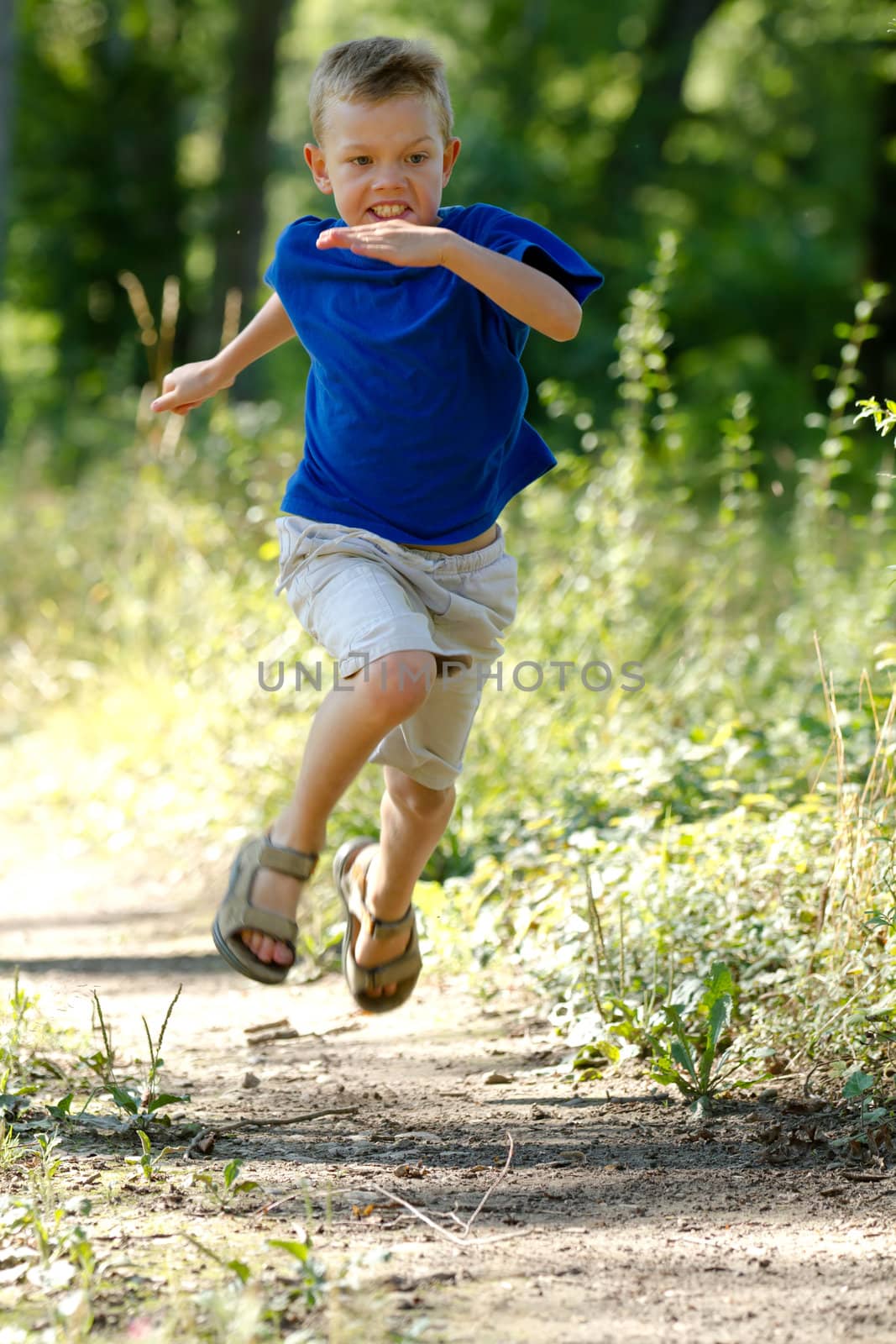 Young boy running in nature by chrisroll