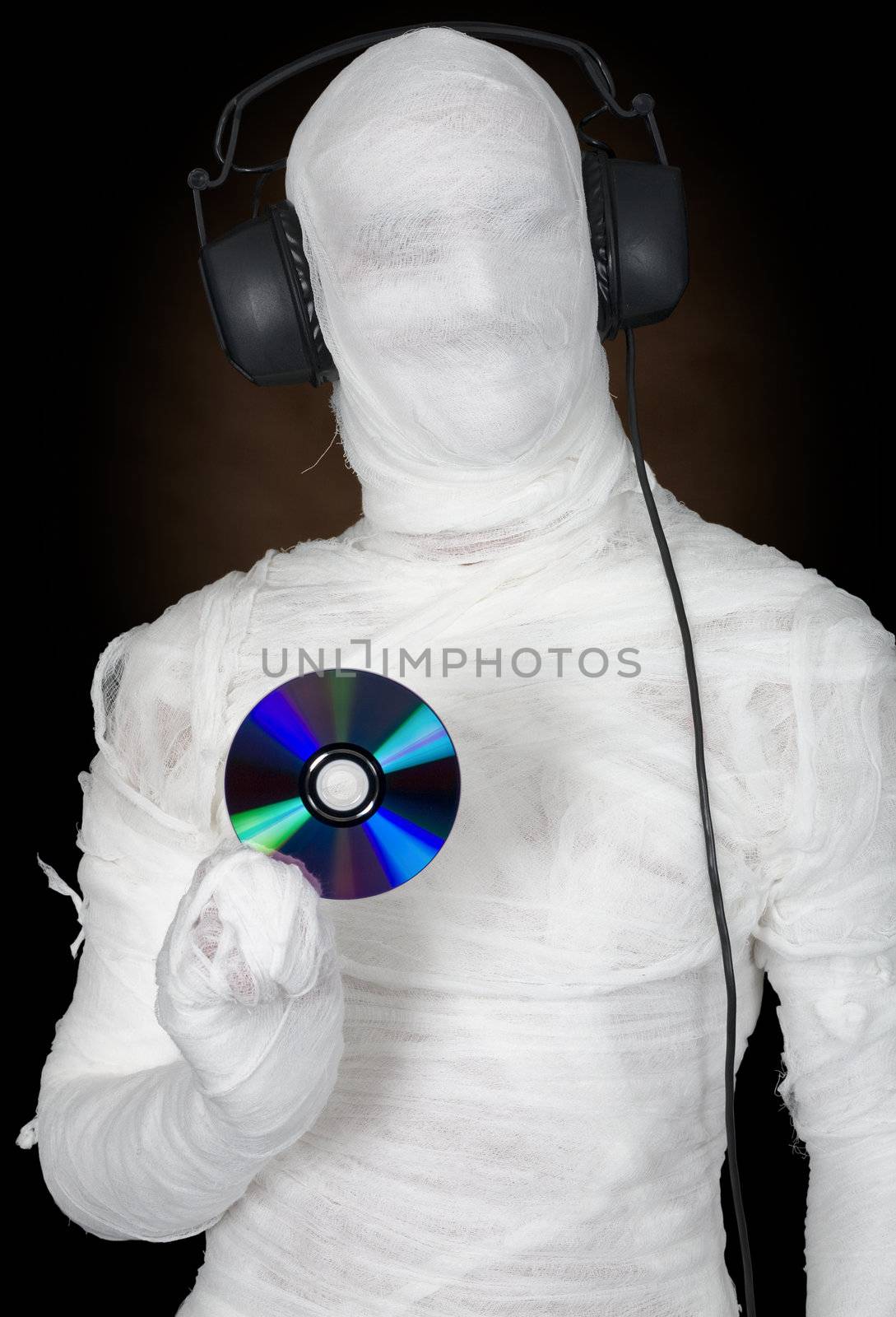 Man in bandage with ear-phones and disc on black