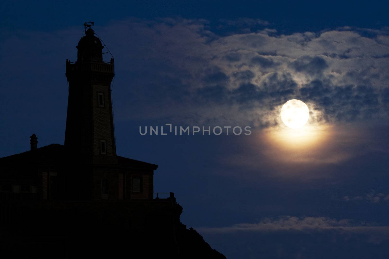 Lighthouse silhouette in the moonlight