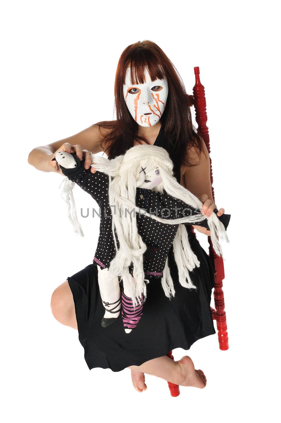 crazy woman in a mask playing with a doll on a white background