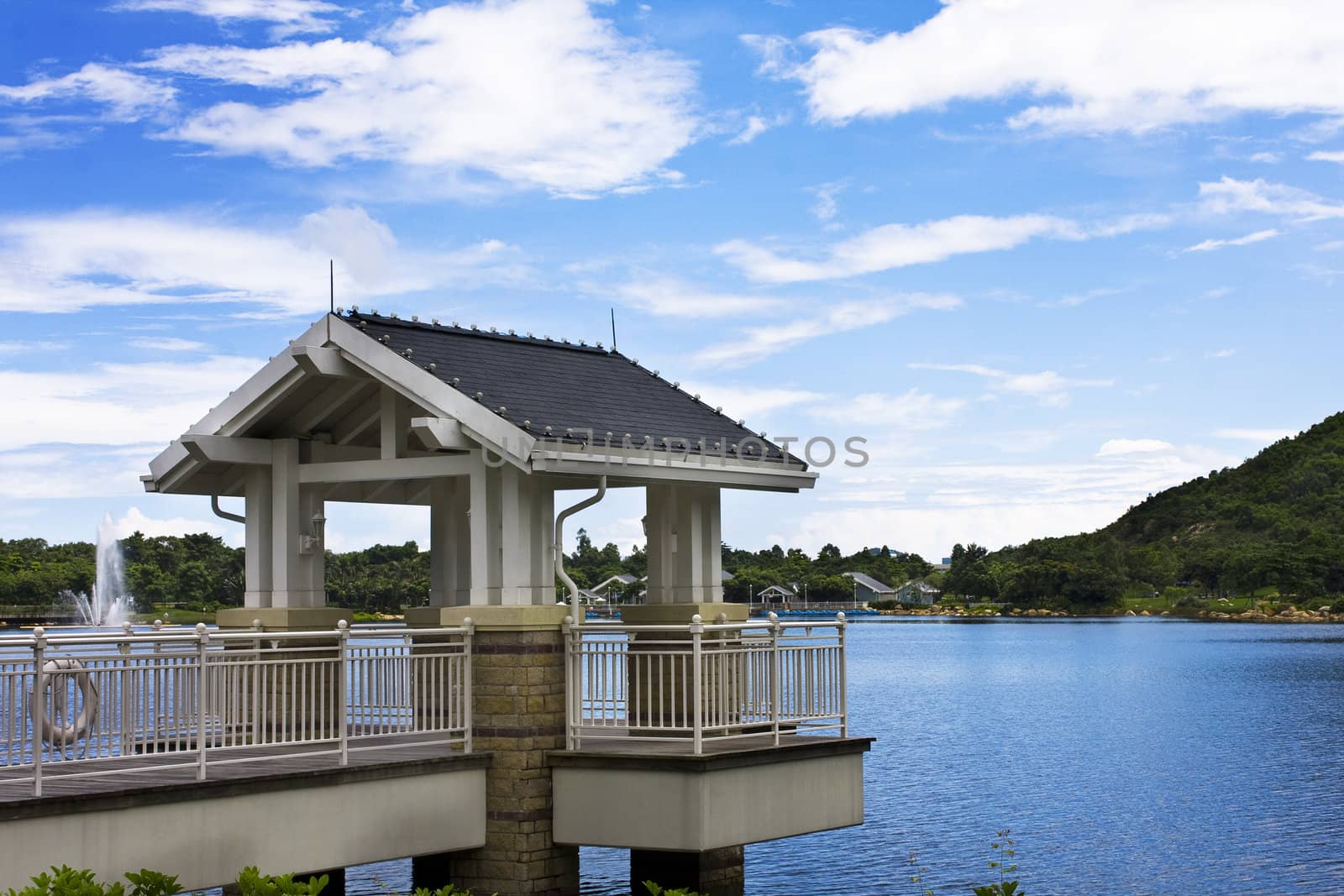 Beautiful spring lake and wooden belvedere in the park.