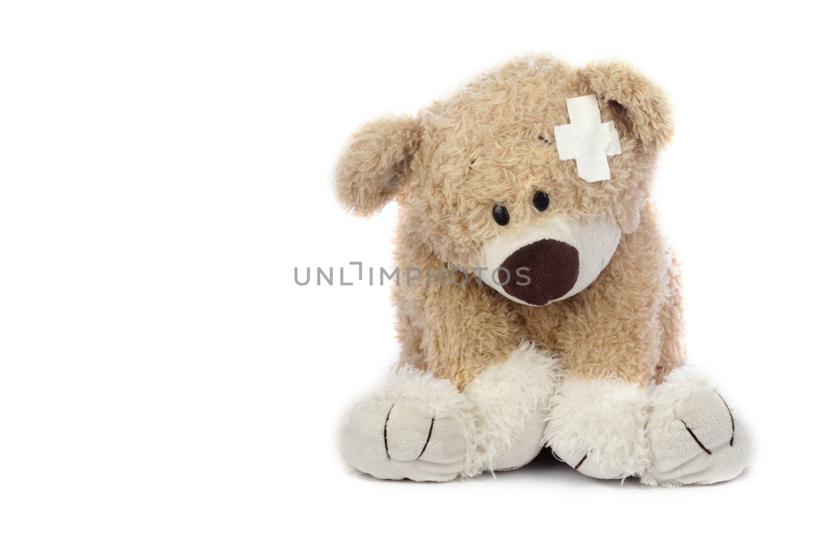 An adorable teddy bear that is sad and hurt.