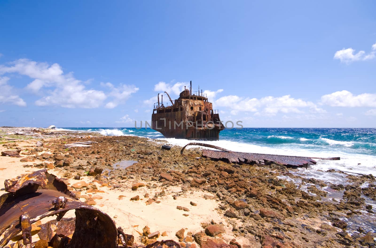 rusty caribbean shipwreck washing ashore on little curacao
