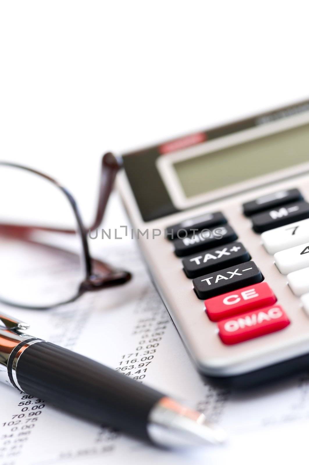 Calculating numbers for income tax return with glasses pen and calculator