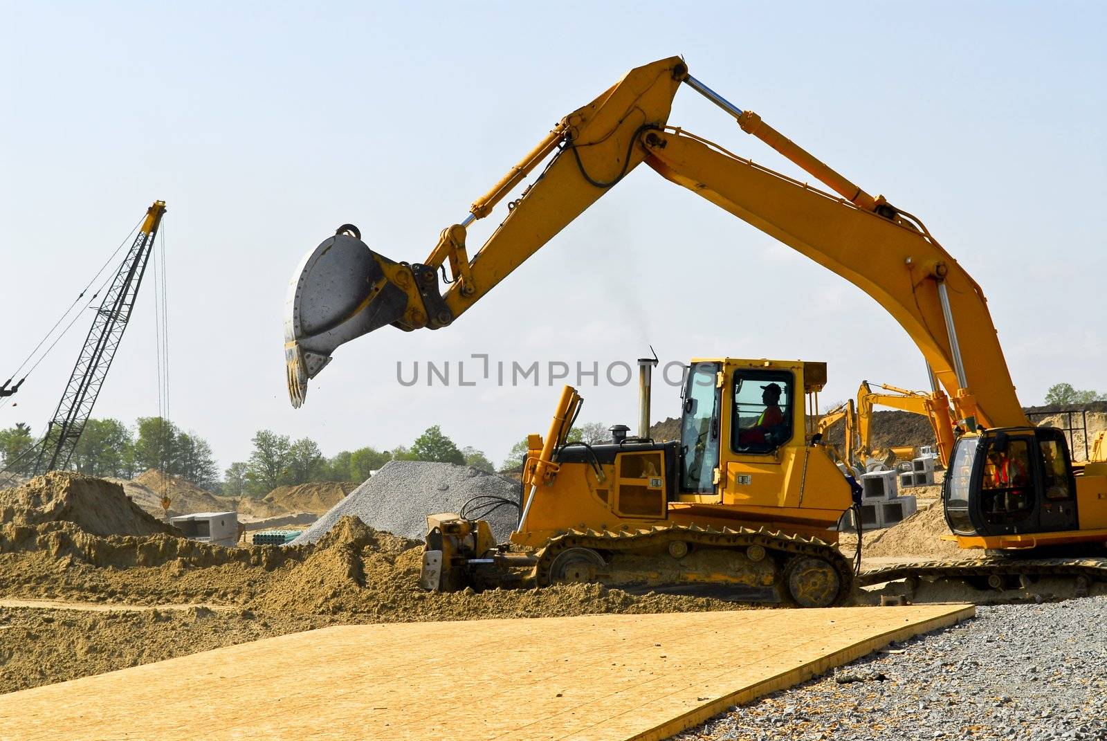 Yellow bulldozer machines digging and moving earth at construction site