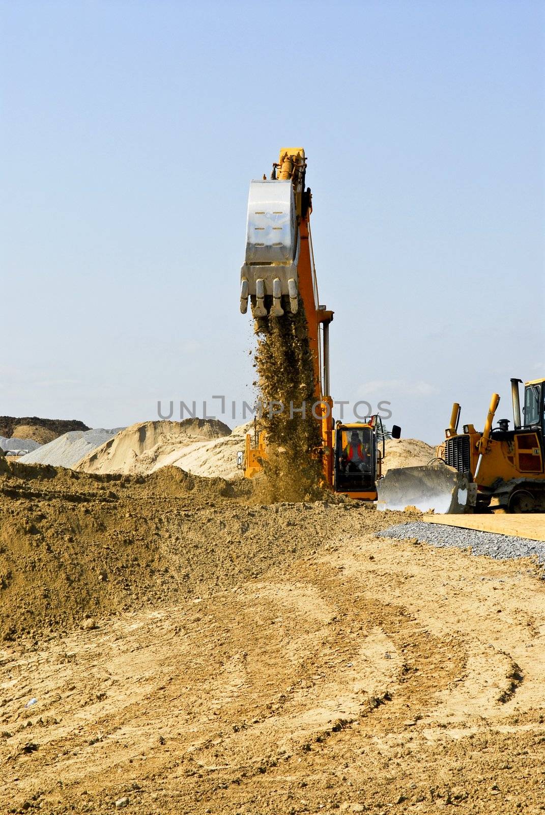 Yellow bulldozer machines digging and moving earth at construction site