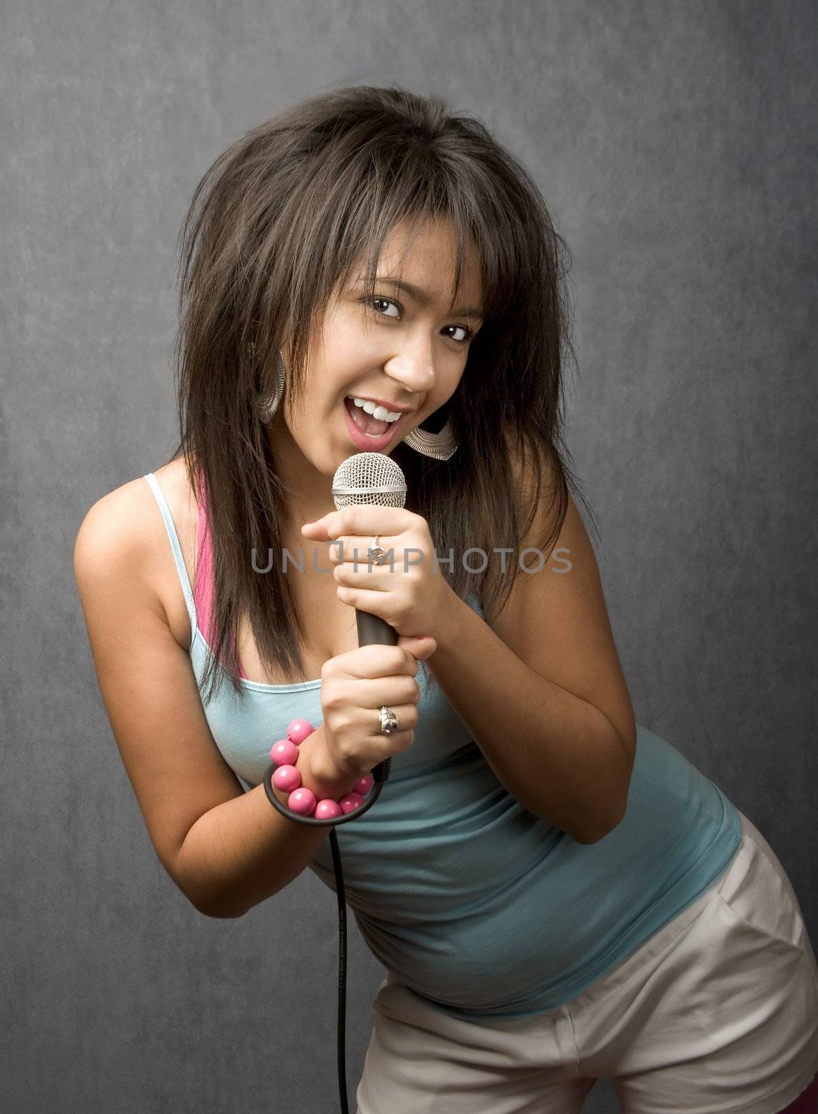 Pretty young singer with a large microphone
