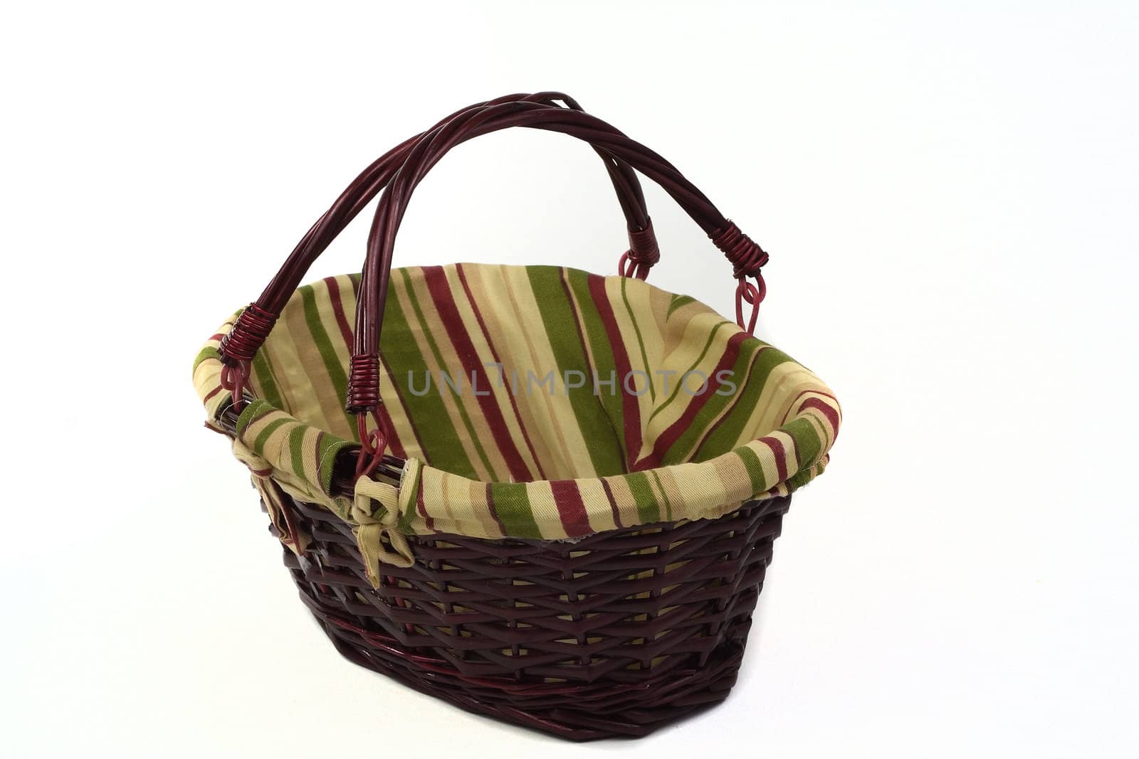 Cane basket with stripped cloth and handles isolated on white background