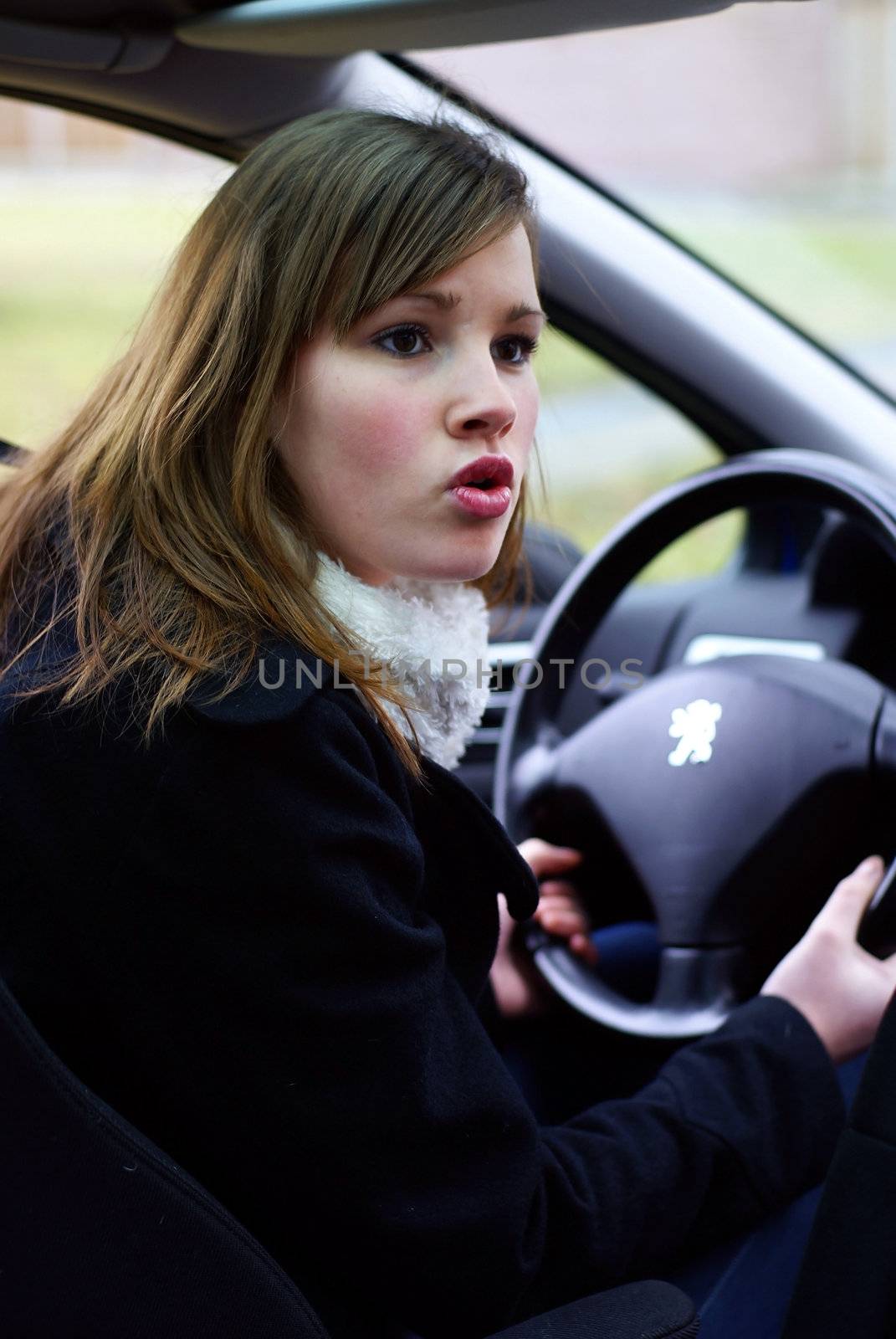 Teen girl mad behind the wheel.