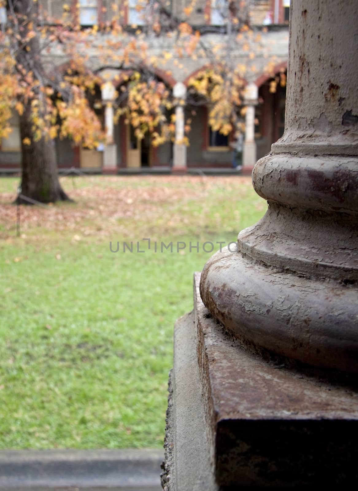 Column with peeling paint and rust overlooking courtyard