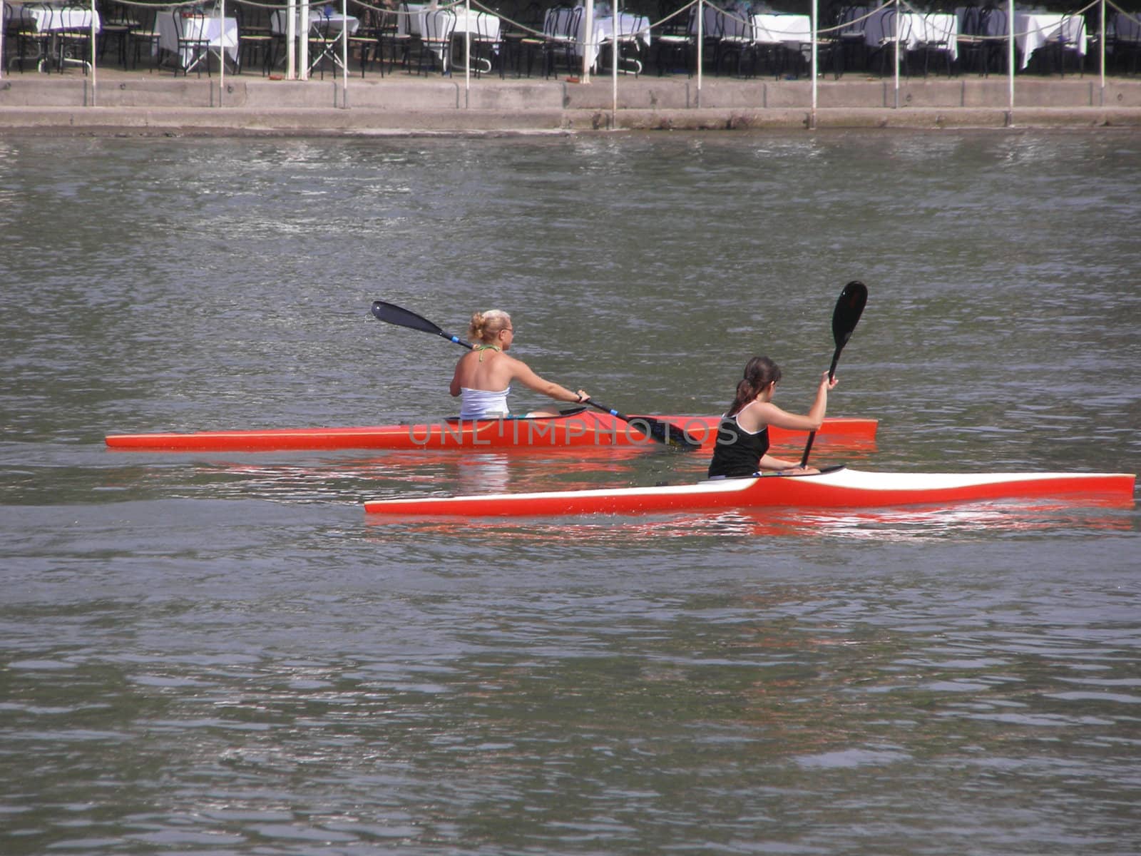 Two girl on canoe canoeing on a river