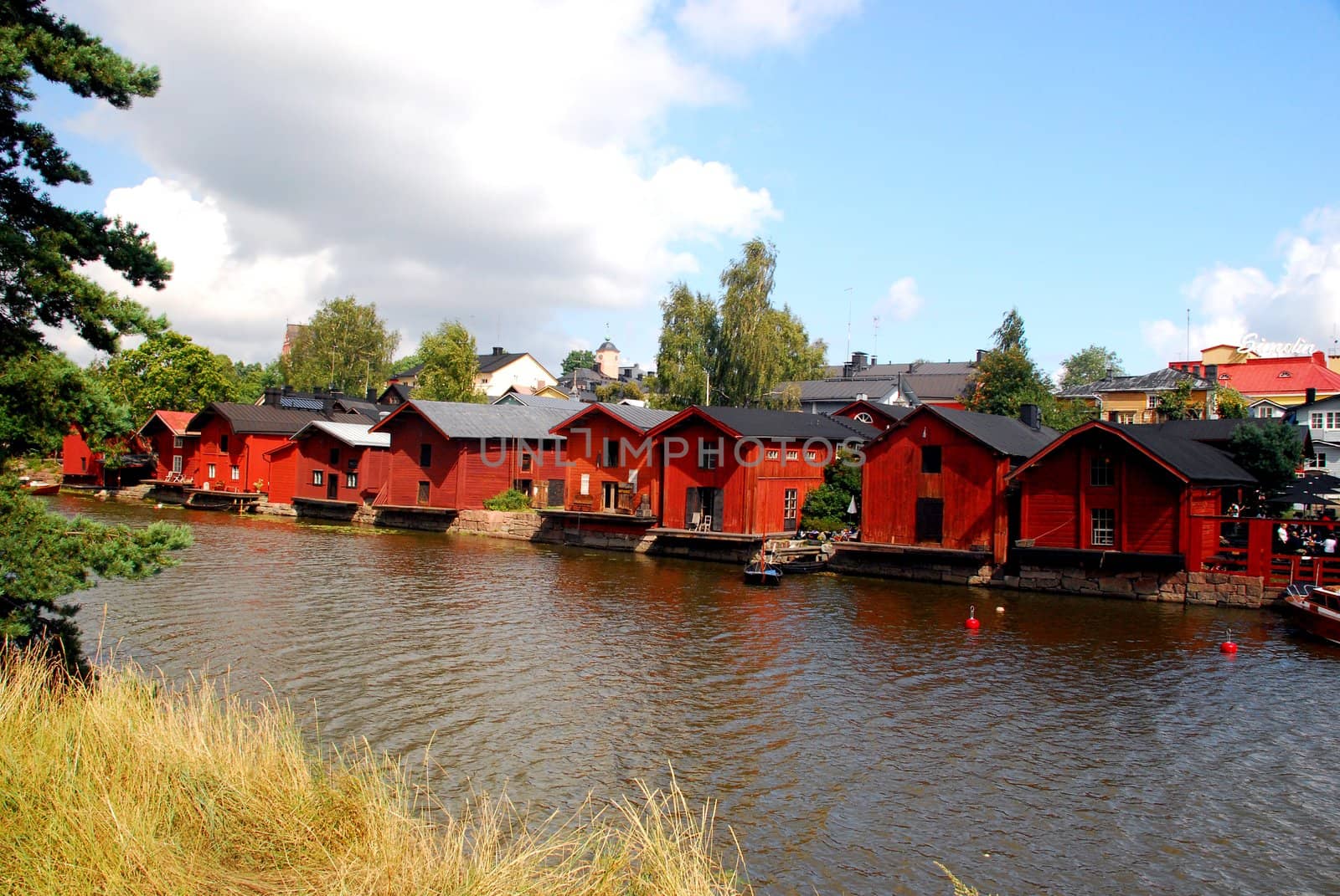 A tipical landscape in porvo, red houses and the river, with the blue cloudy sky in the background.