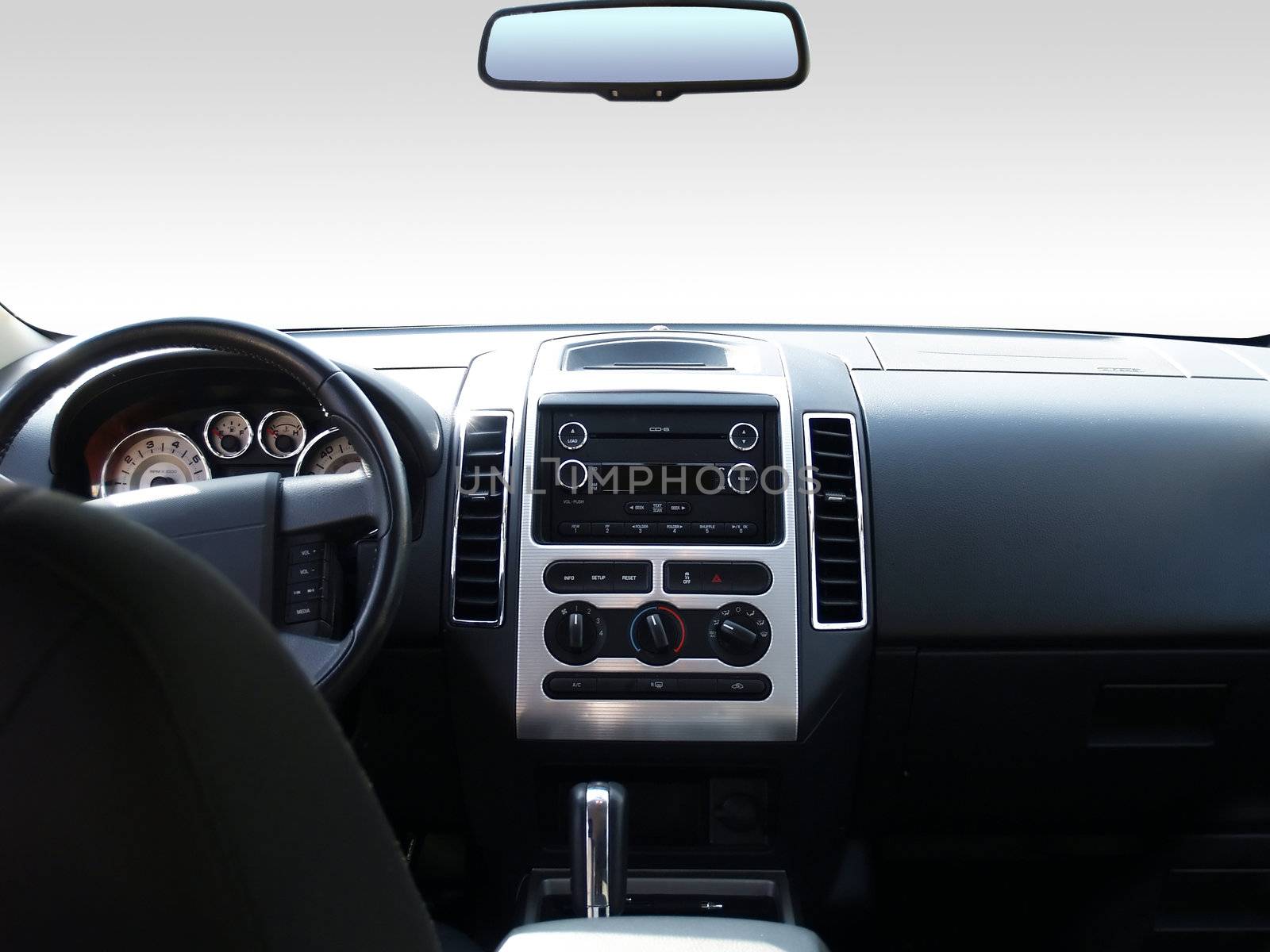 View of the interior of a modern automobile showing the dashboard and rear view mirror. A clipping path of the windshield and mirror are included so you can replace it with whatever you like!