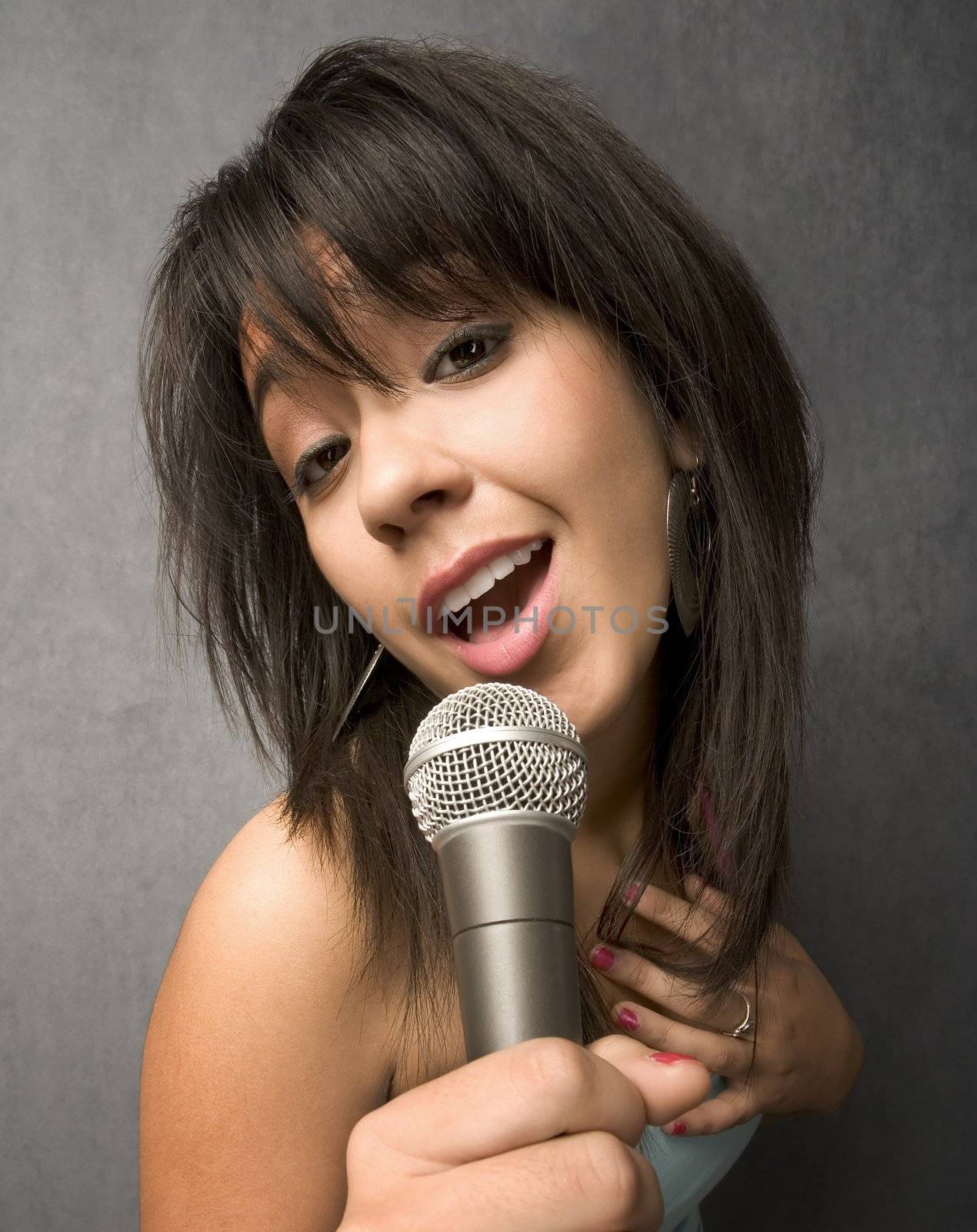 Pretty young singer with a large microphone