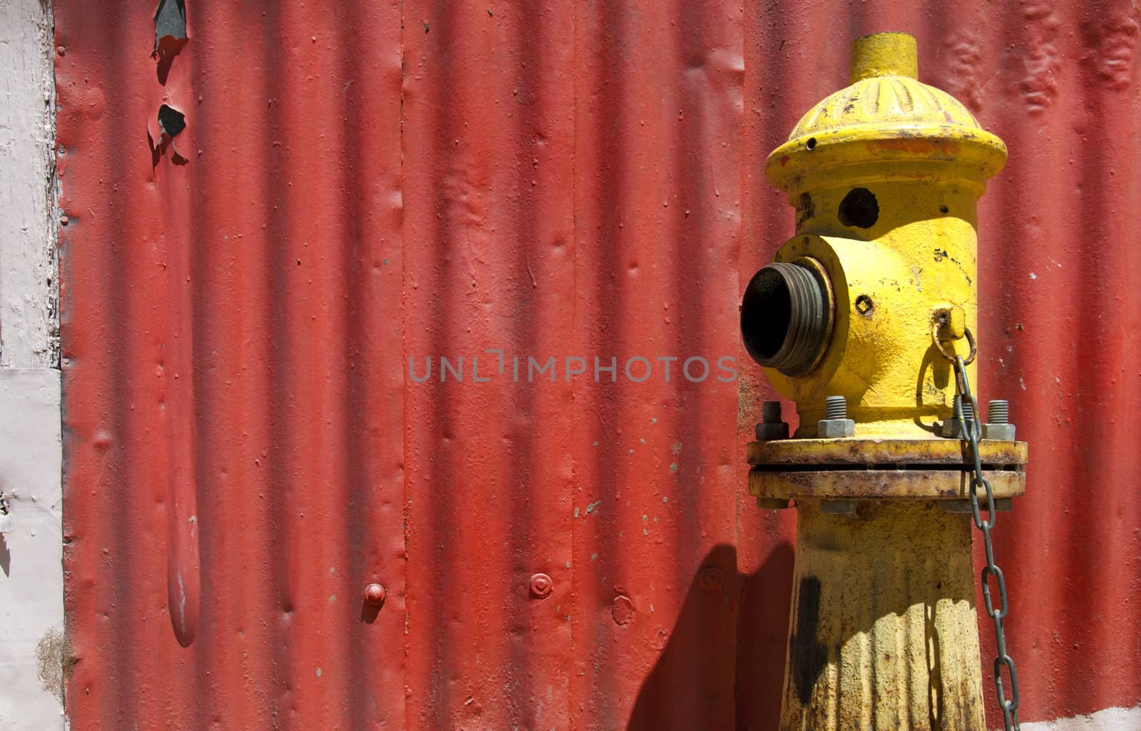Street water pump against red metal wall in Valpariso, Chile 