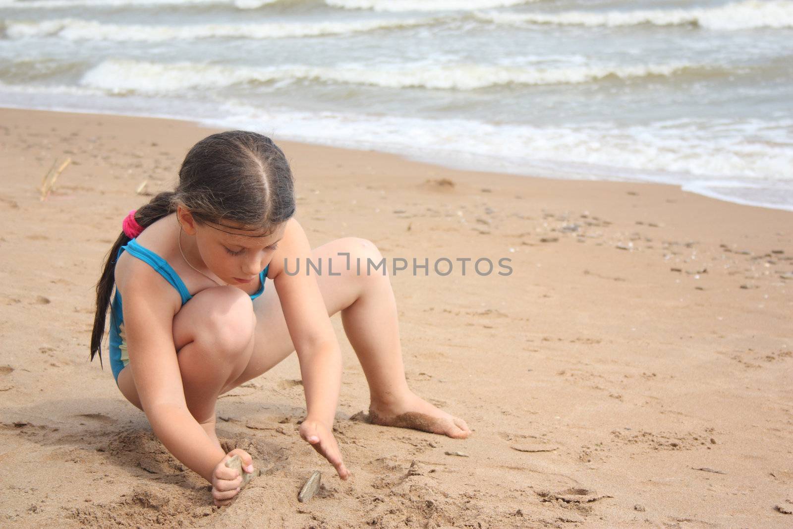  Little girl on the beach building sand castle