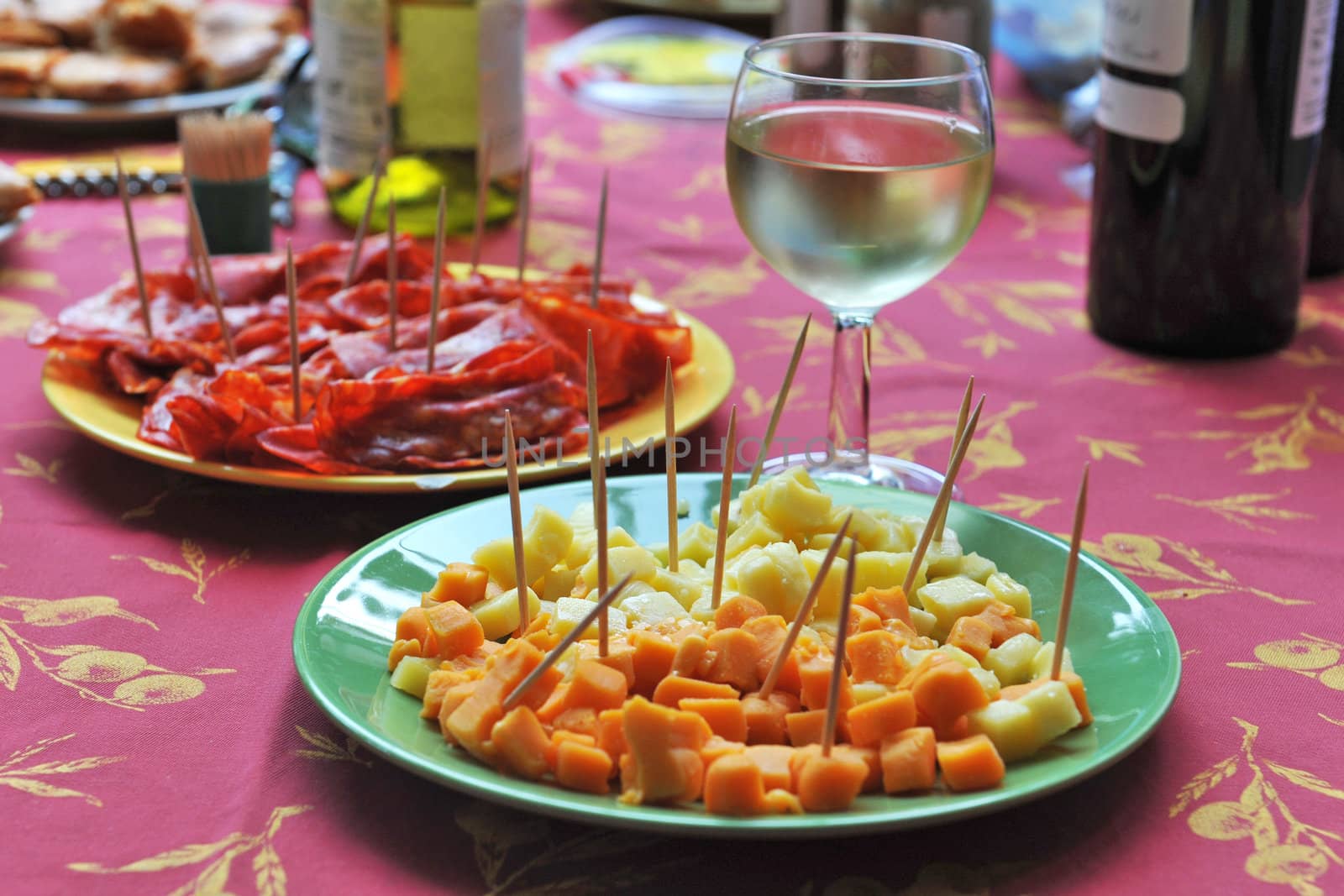 table with glass of white wine and food for appetizer