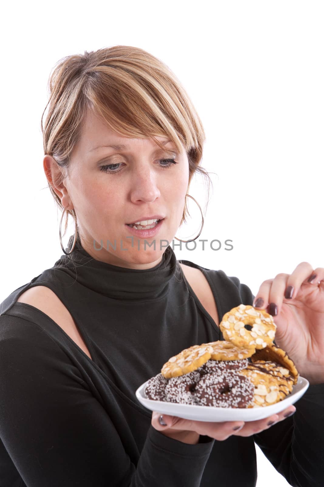 Attractive young woman taking a cookie from the plate