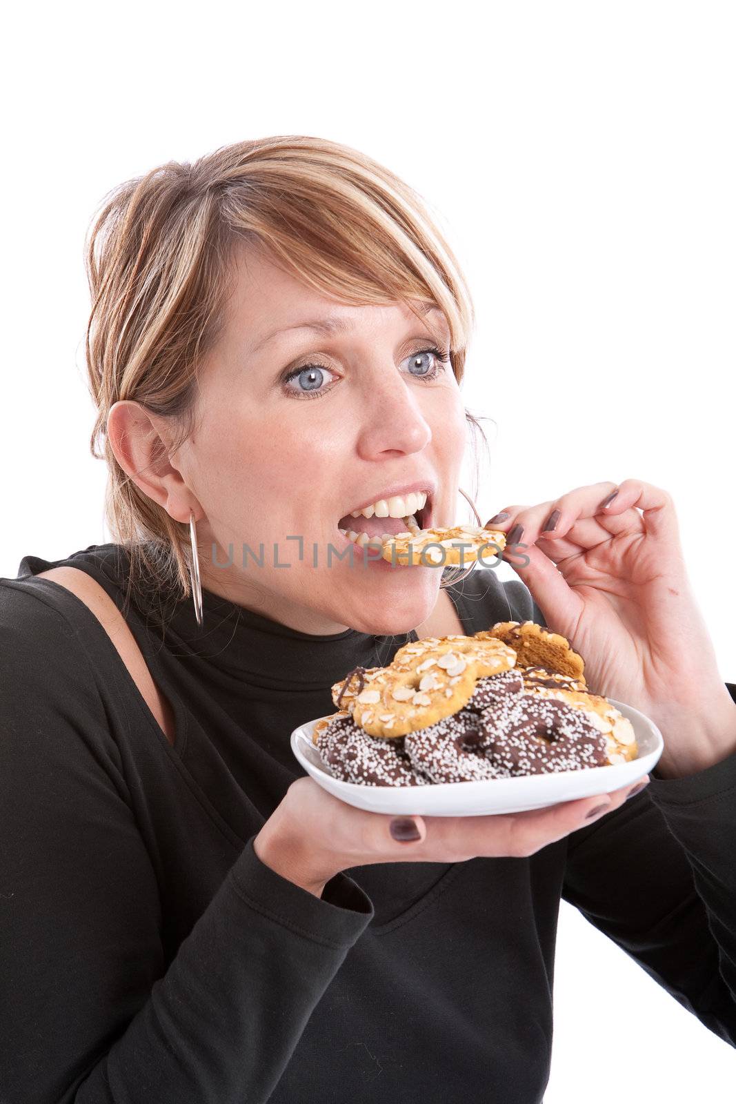 Pretty blond girl taking a bite out of a cookie