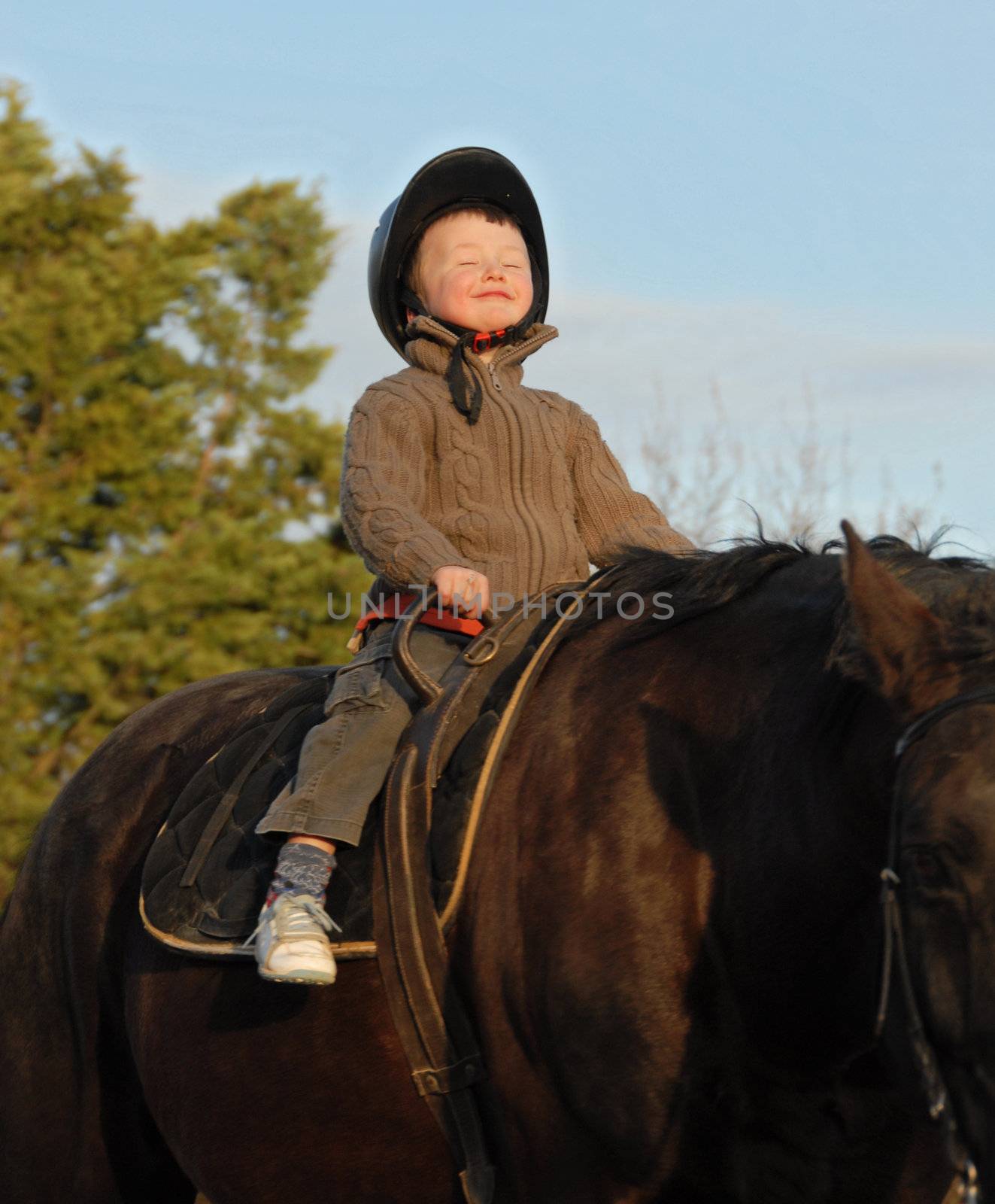 little boy and her black stallion happy... focus on the head of child