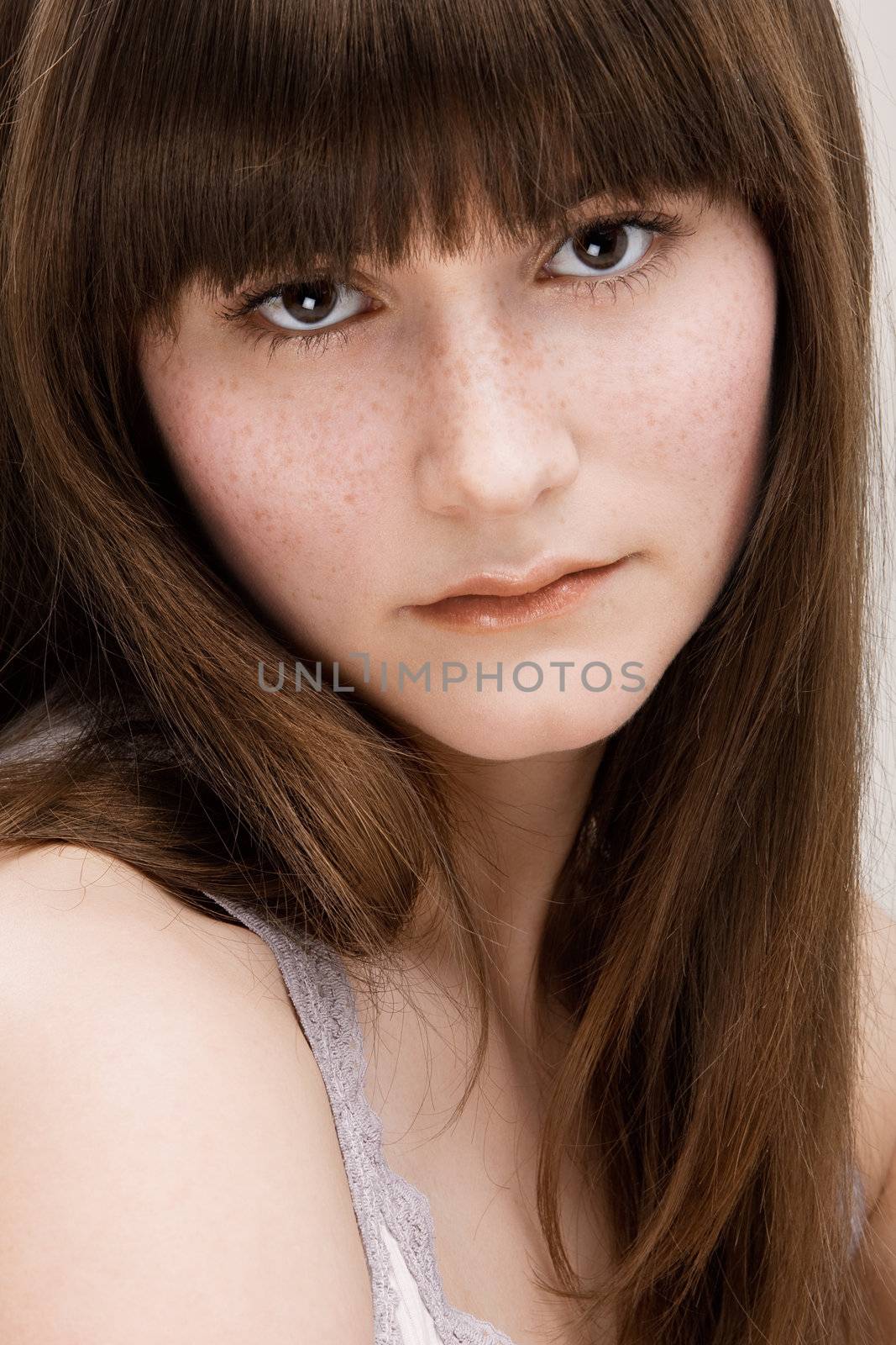 Desaturated portrait of young beautiful girl with freckles