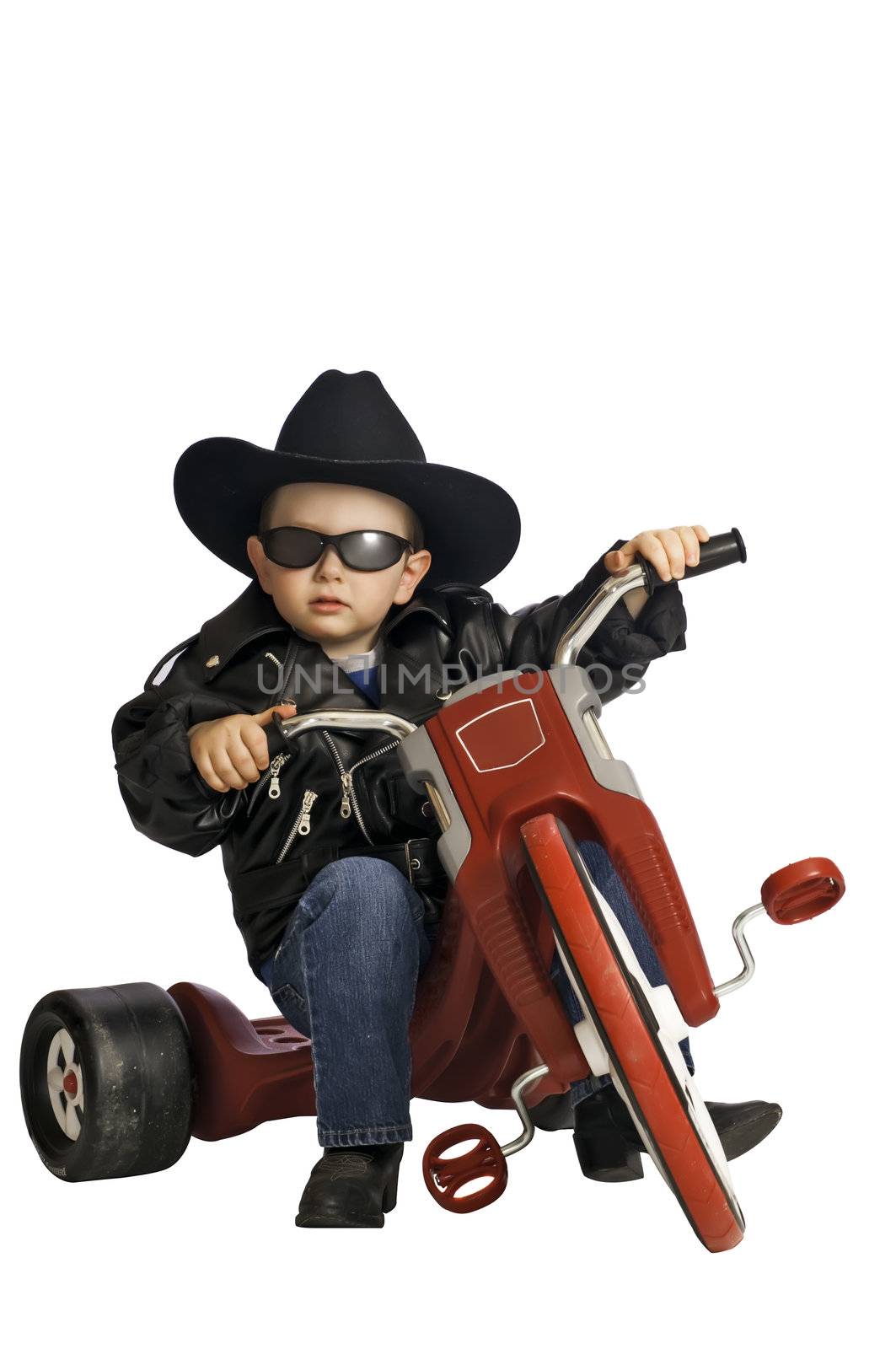 Two year old baby boy playing like a biker on his tricycle