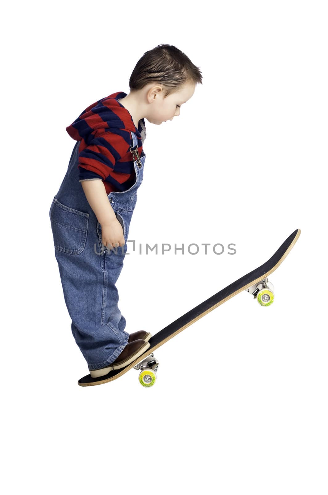 Curious two year old studying how to ride a skateboard like his older brother.