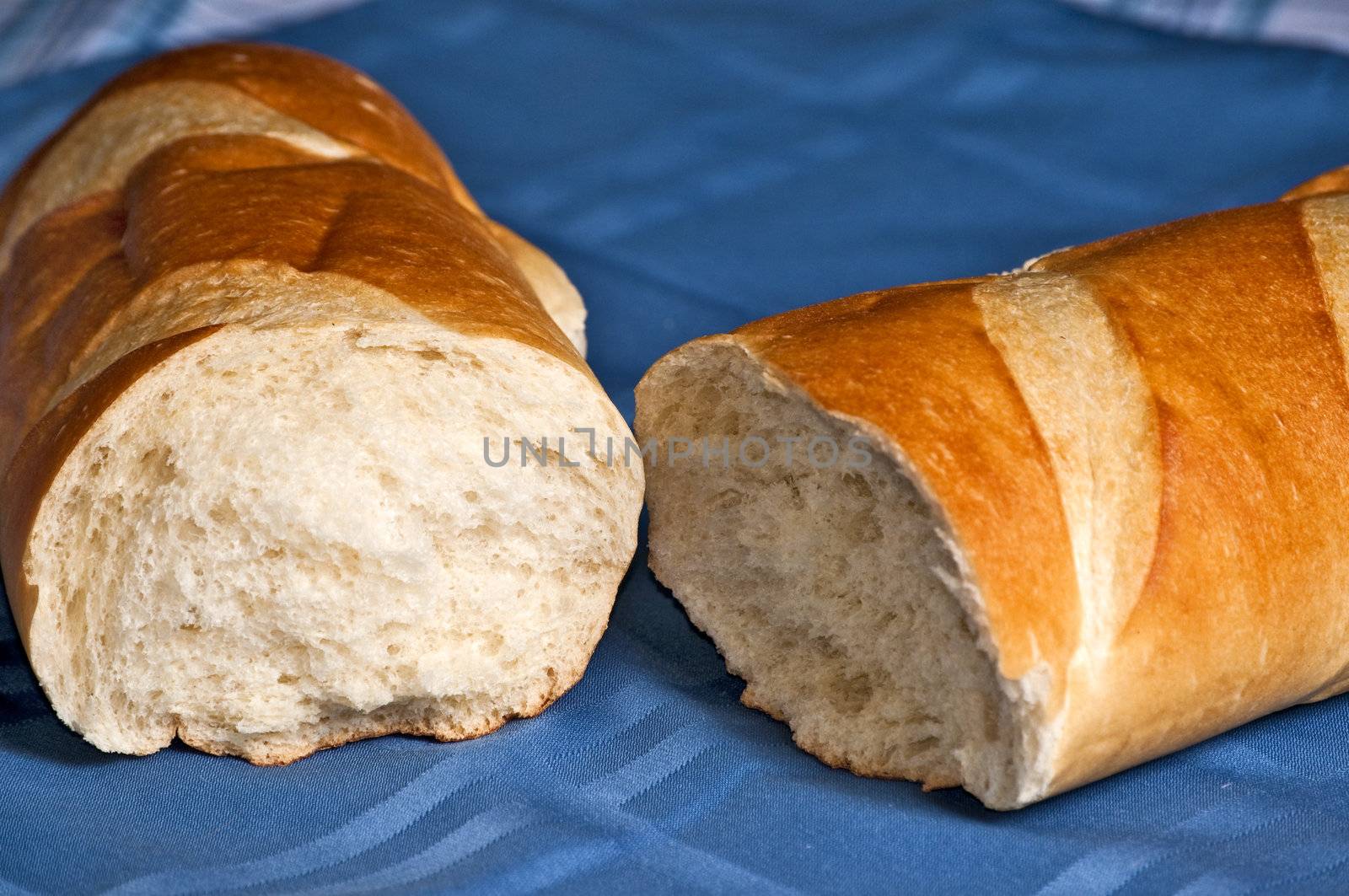 A delicious loaf of French bread broken open ready to butter and eat.