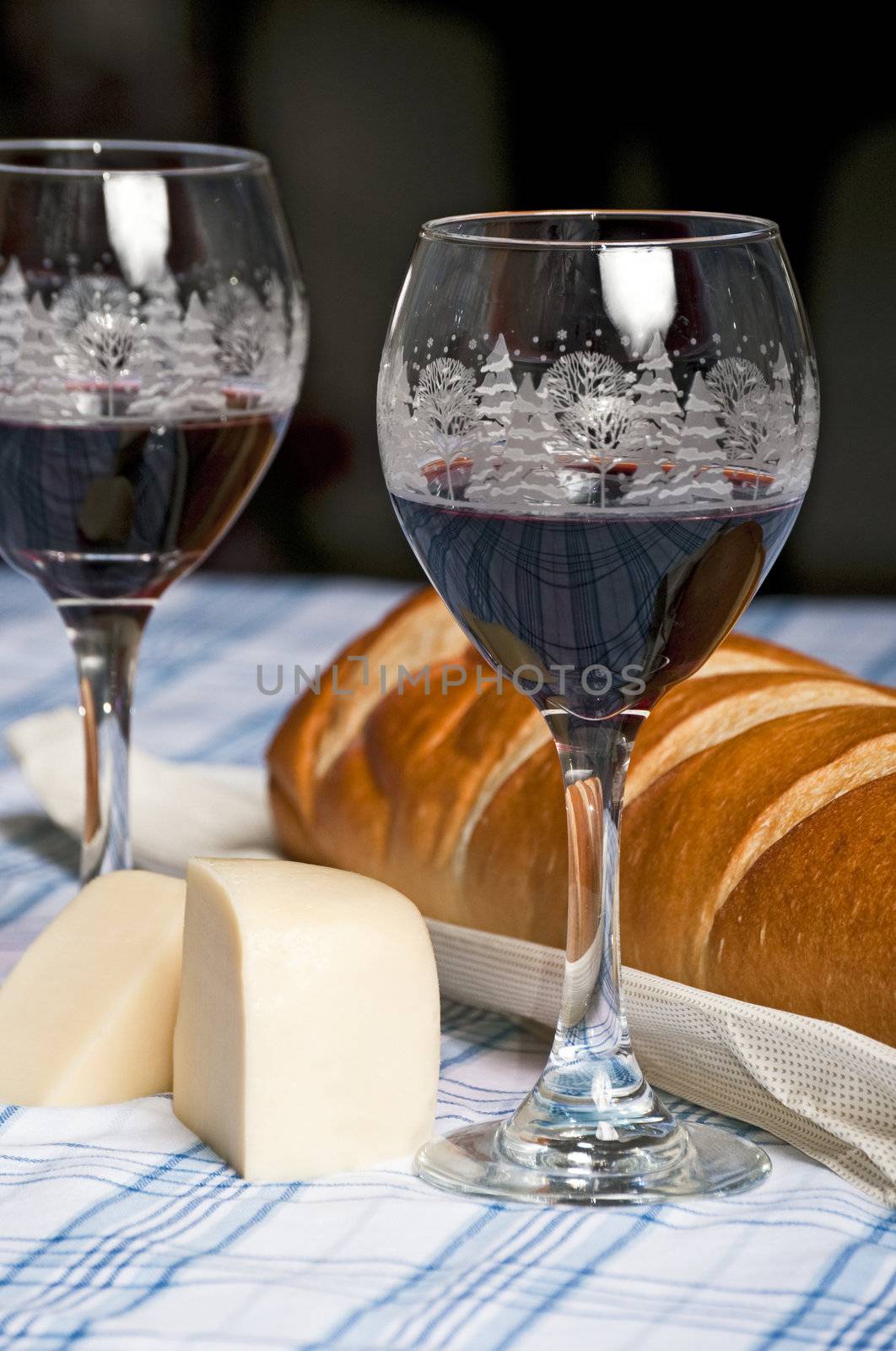 Wine in Holiday glasses with French bread and cheese to celebrate Christmas