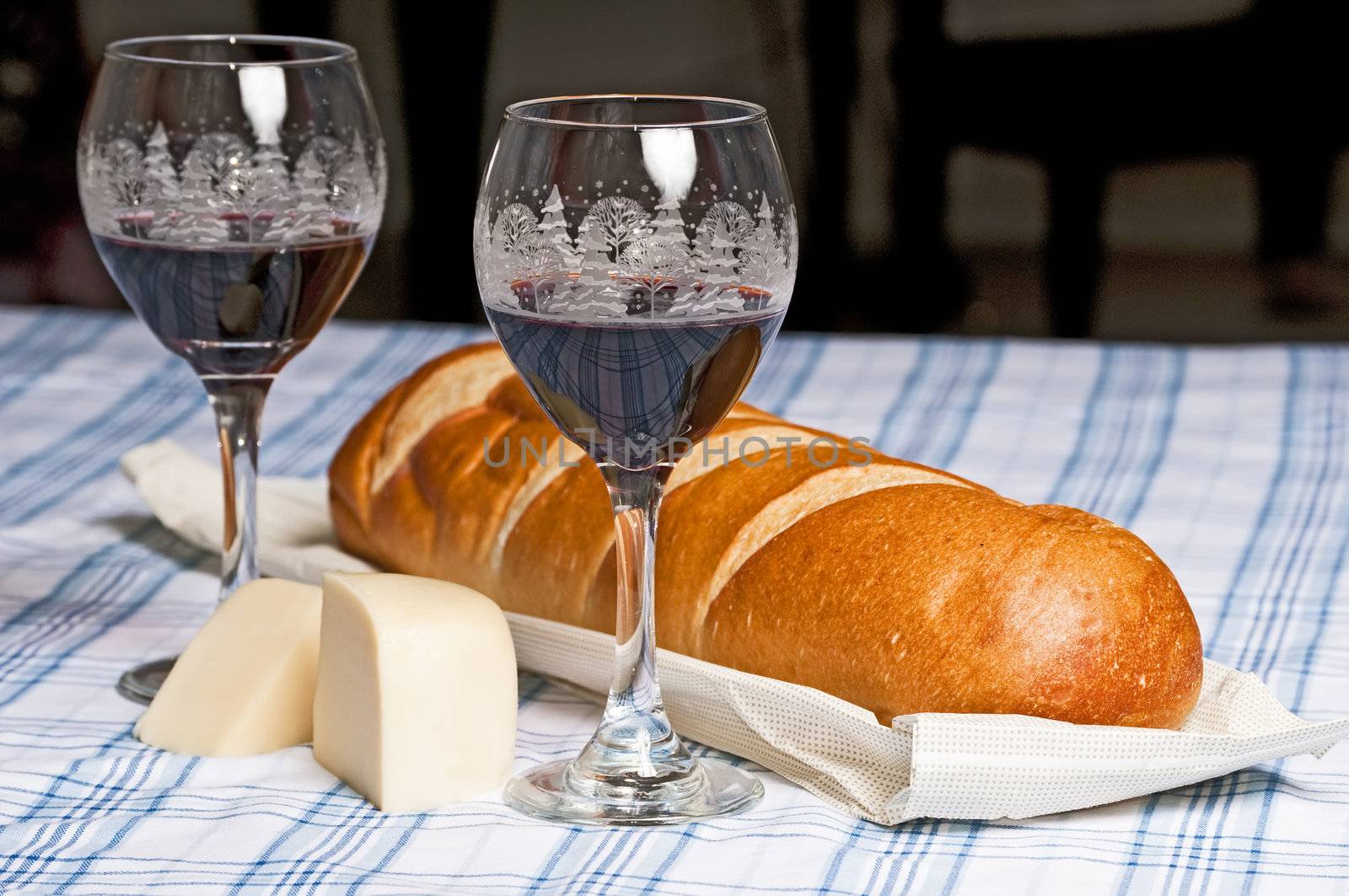 French bread, cheese and wine in Christmas glasses to celebrate the season.