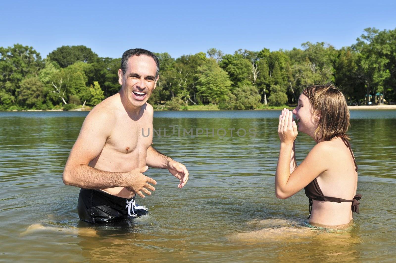 Father and daughter splashing in a lake