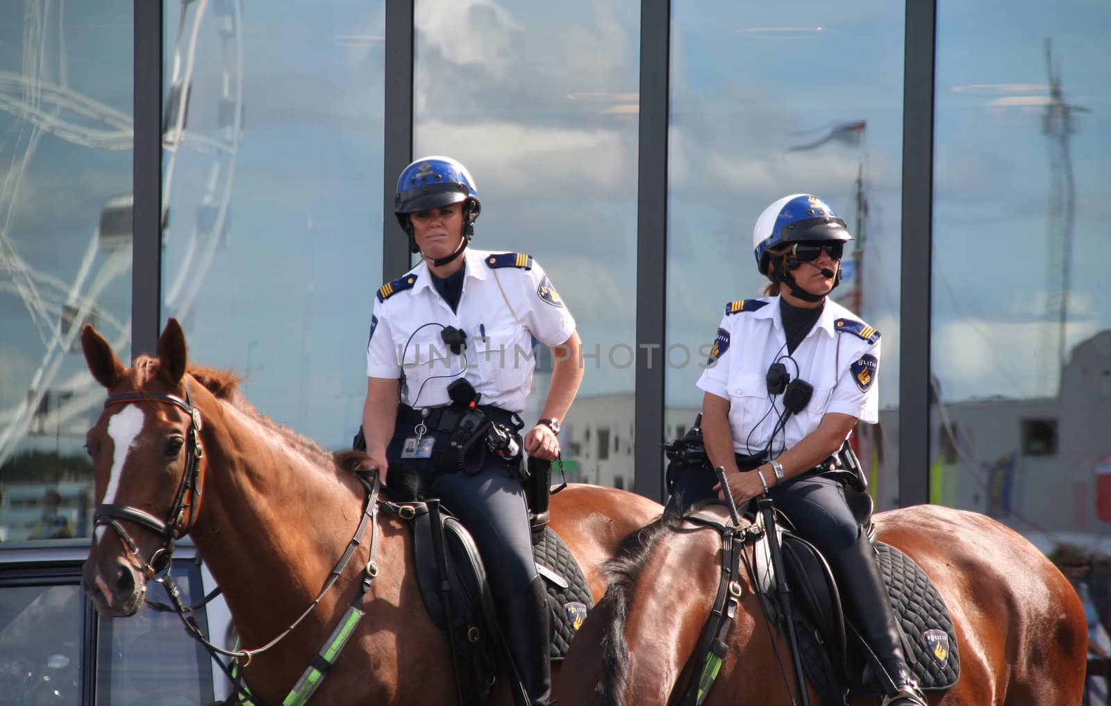 AMSTERDAM, AUGUST 19, 2010: Female police officers on horseback watch the crowd at Sail 2010 in Amsterdam, Holland on august 19, 2010
