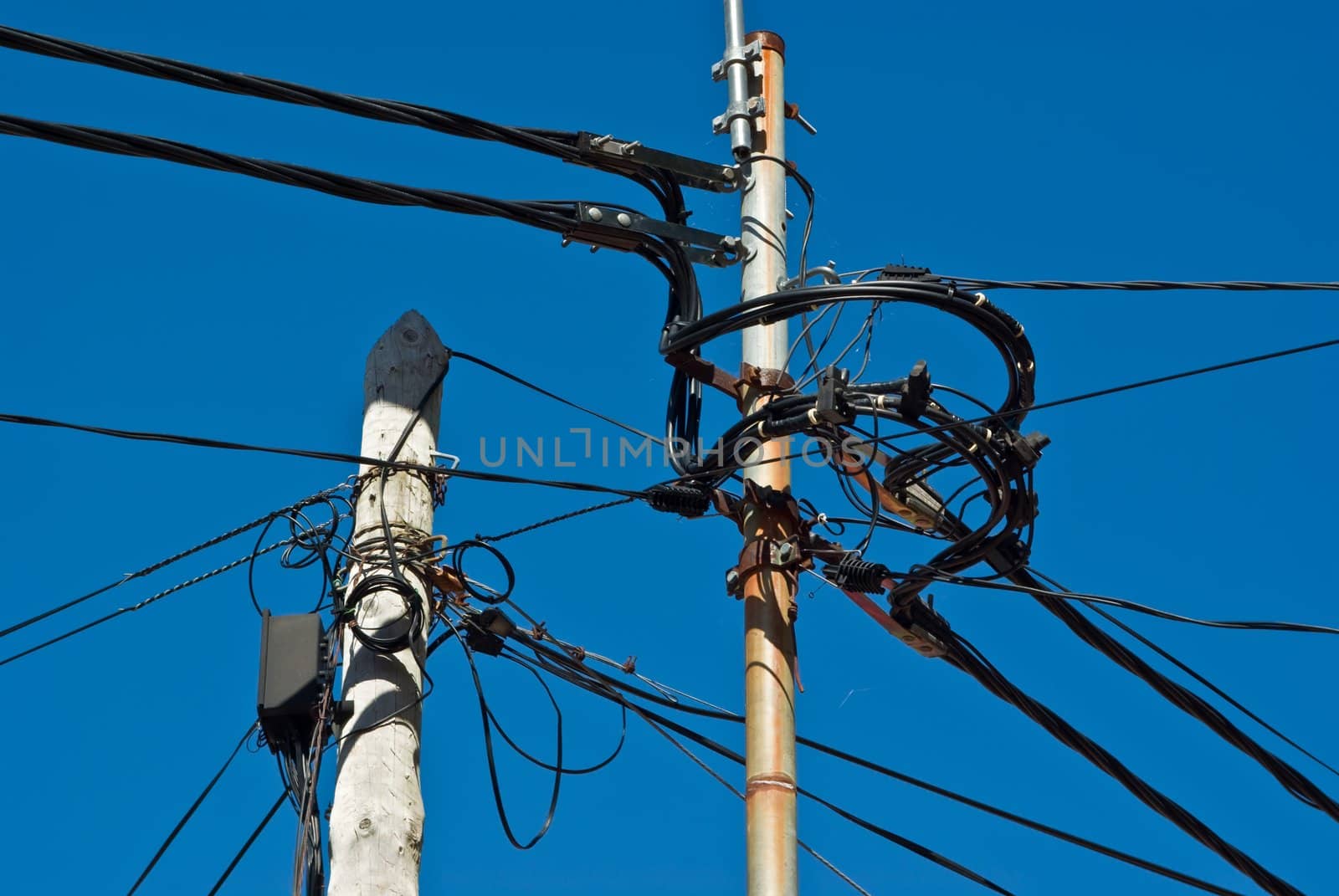 Poles with a mess of wires, taken on Madeira, Portugal.