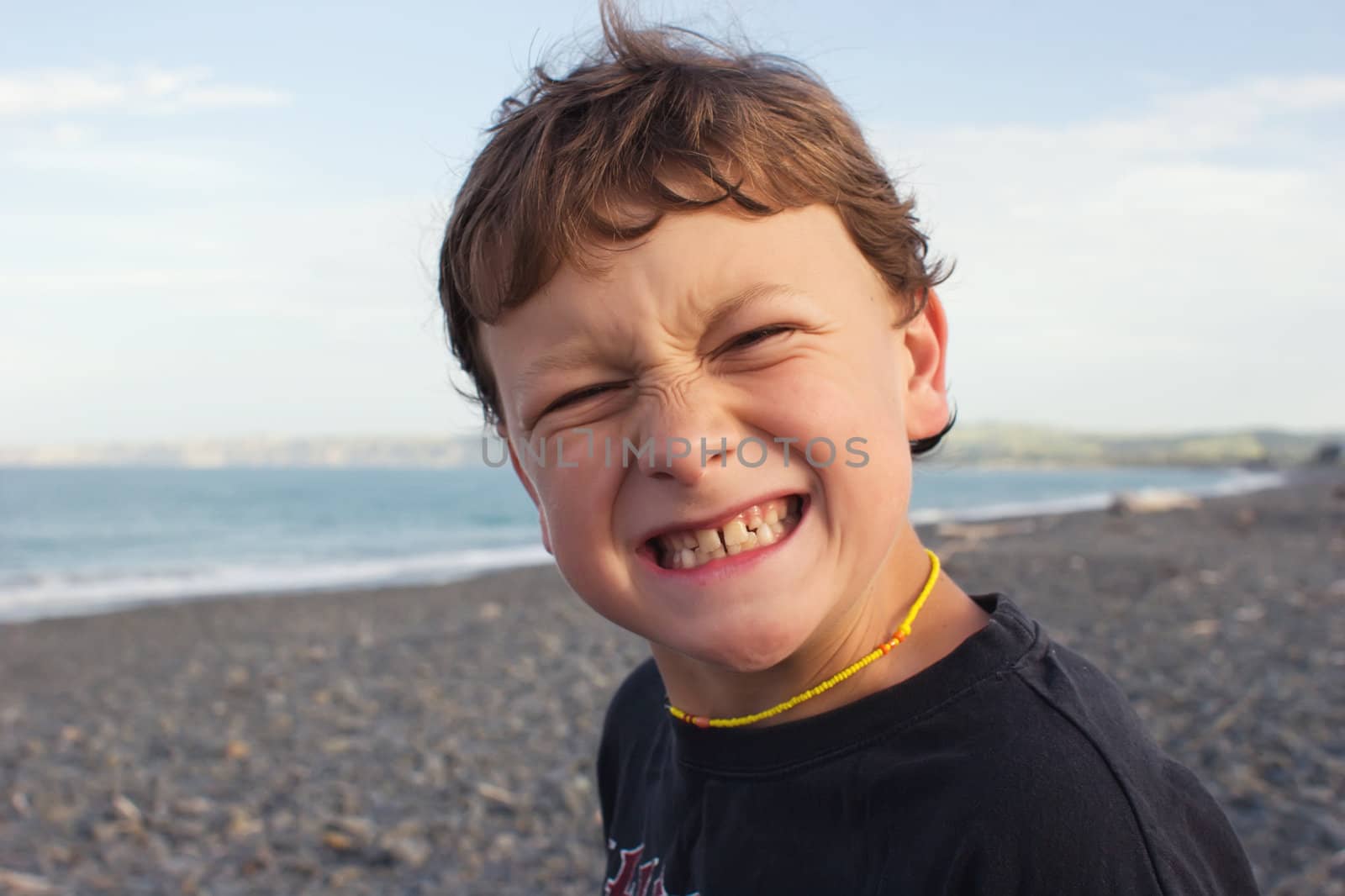 A young male grimaces while at the beach