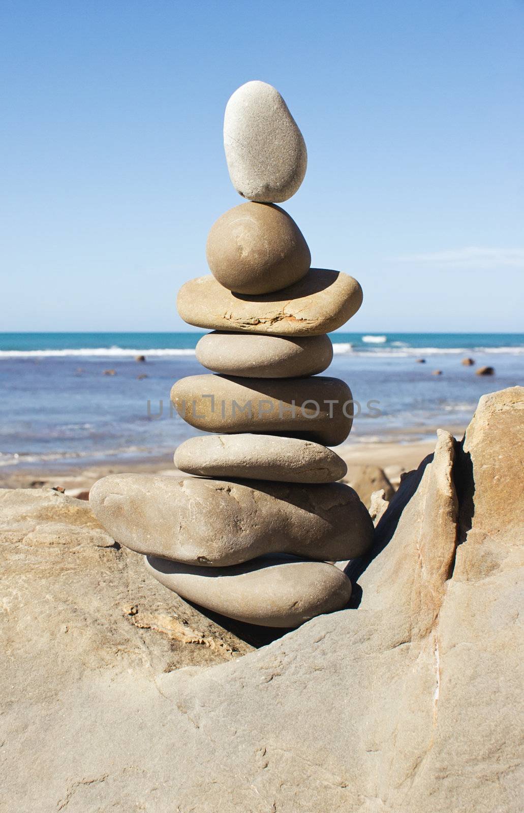 A stack of balanced stones with the beach in the background