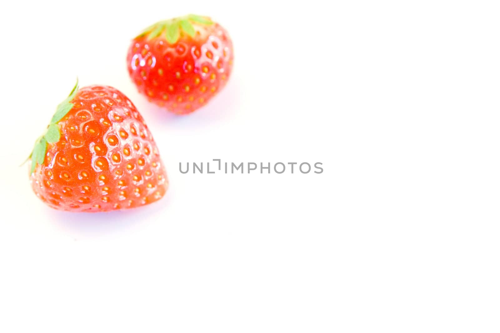 high key image of two strawberries with a shallow dof on a white background