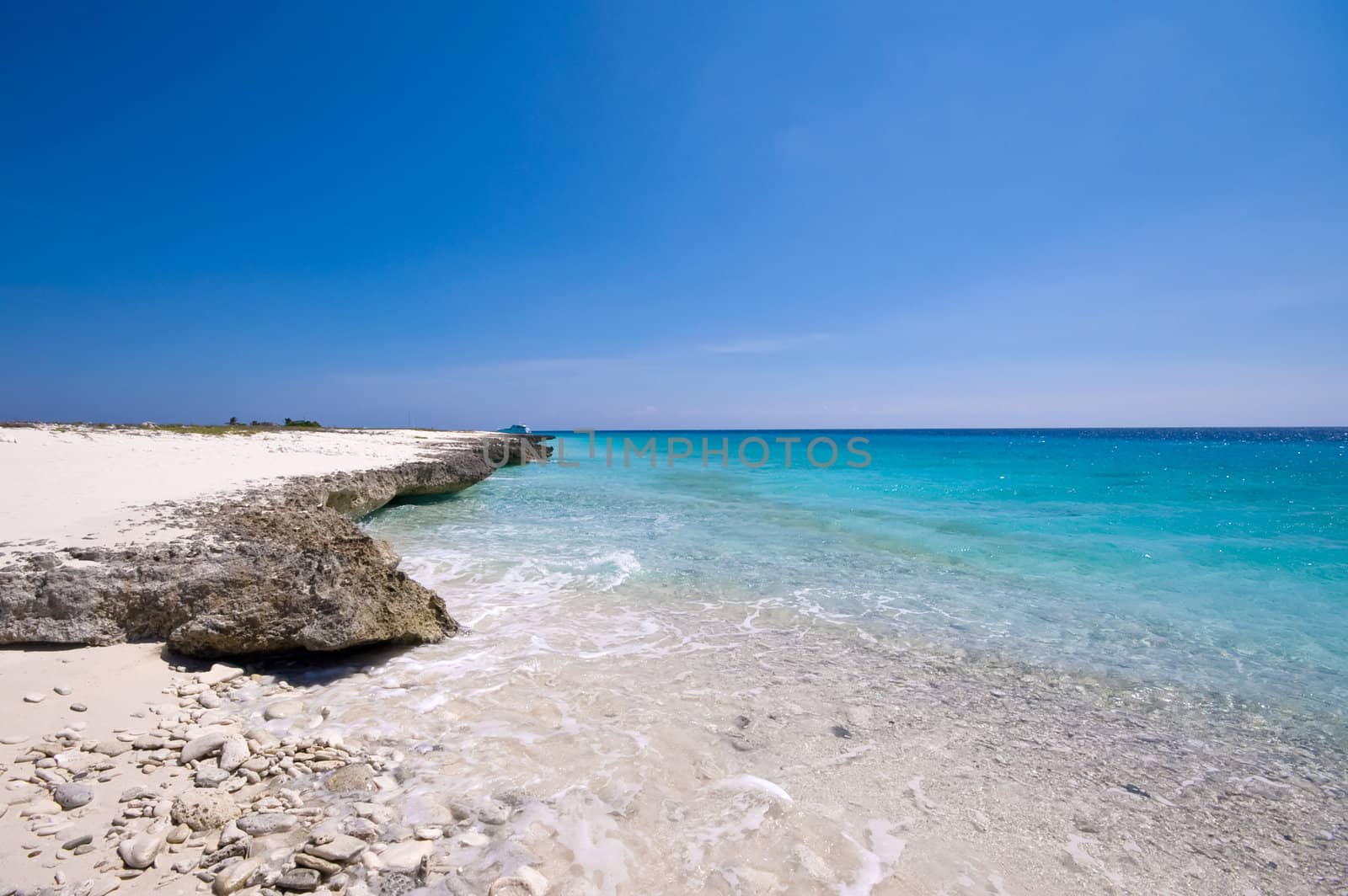 tropical turquoise sea landscape with a rocky shore line
