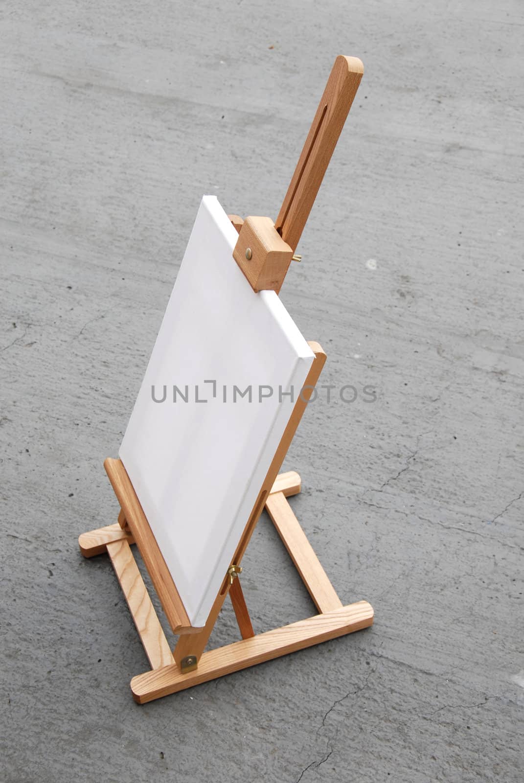 Easel with blank canvas on gray concrete background