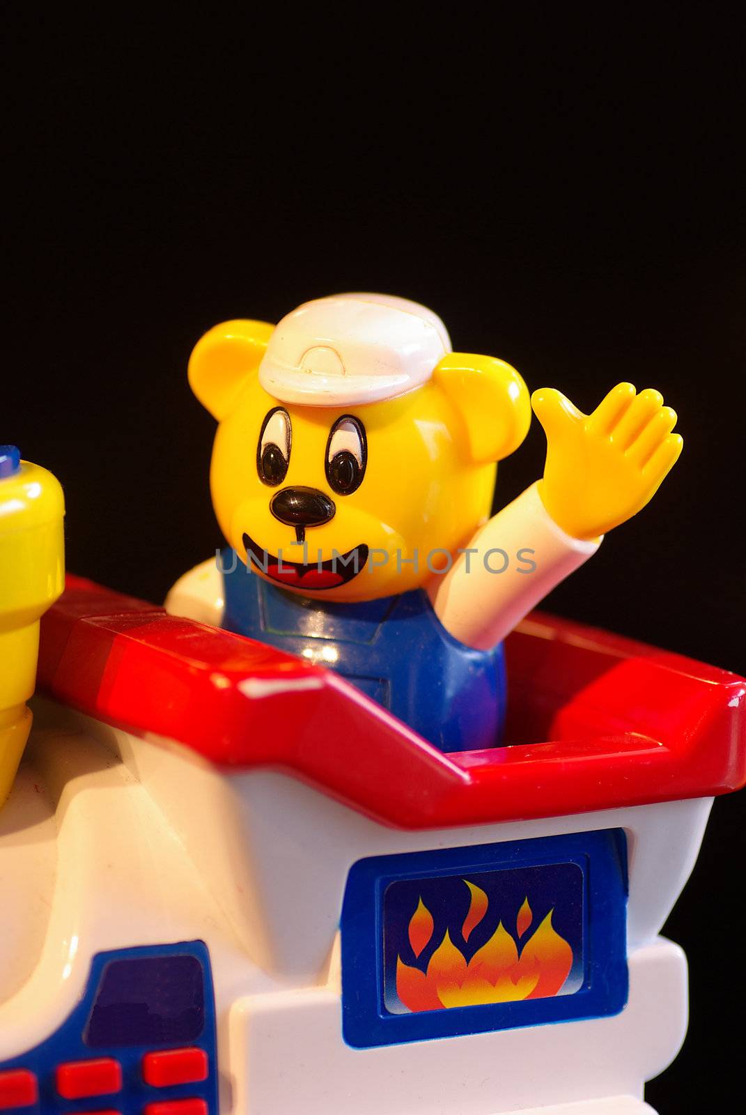 Childrens toy, a yellow bear driving a train and waving