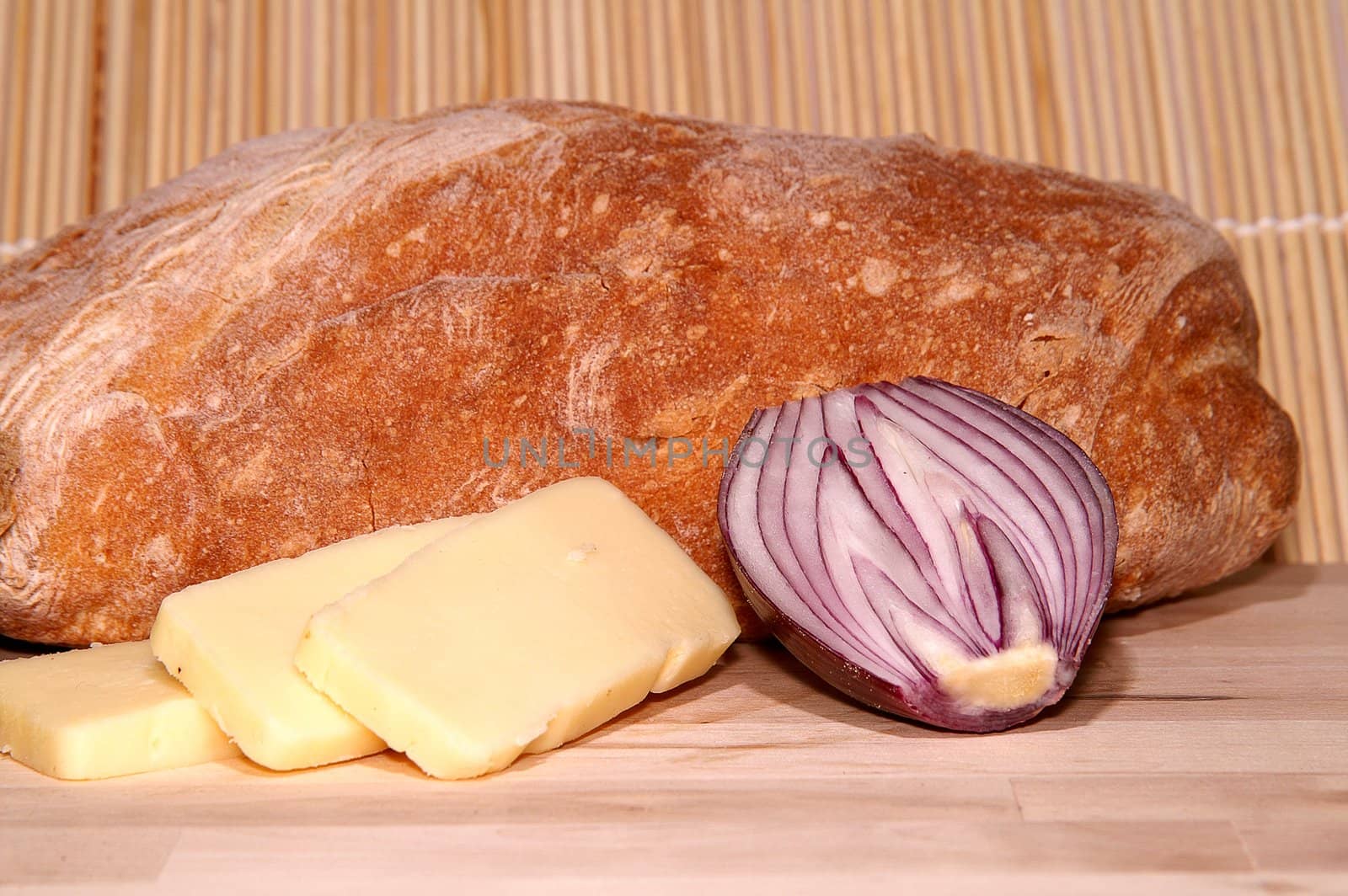 ciabatta bread with cheese slices and onion on wooden plate