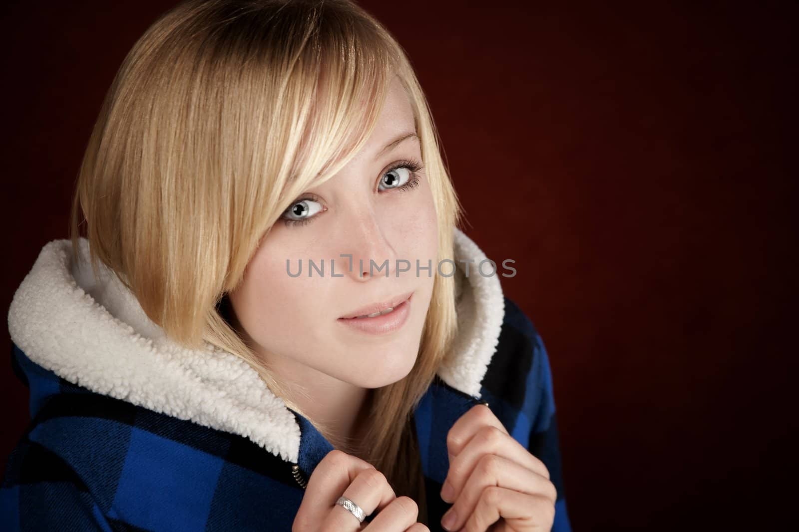 Pretty young blonde teenage girl in blue jacket