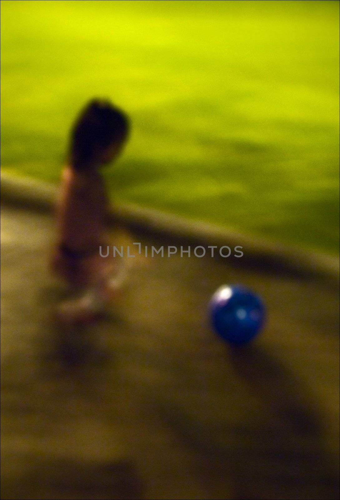 The girl and a ball. The little girl plays park a ball late at night.
