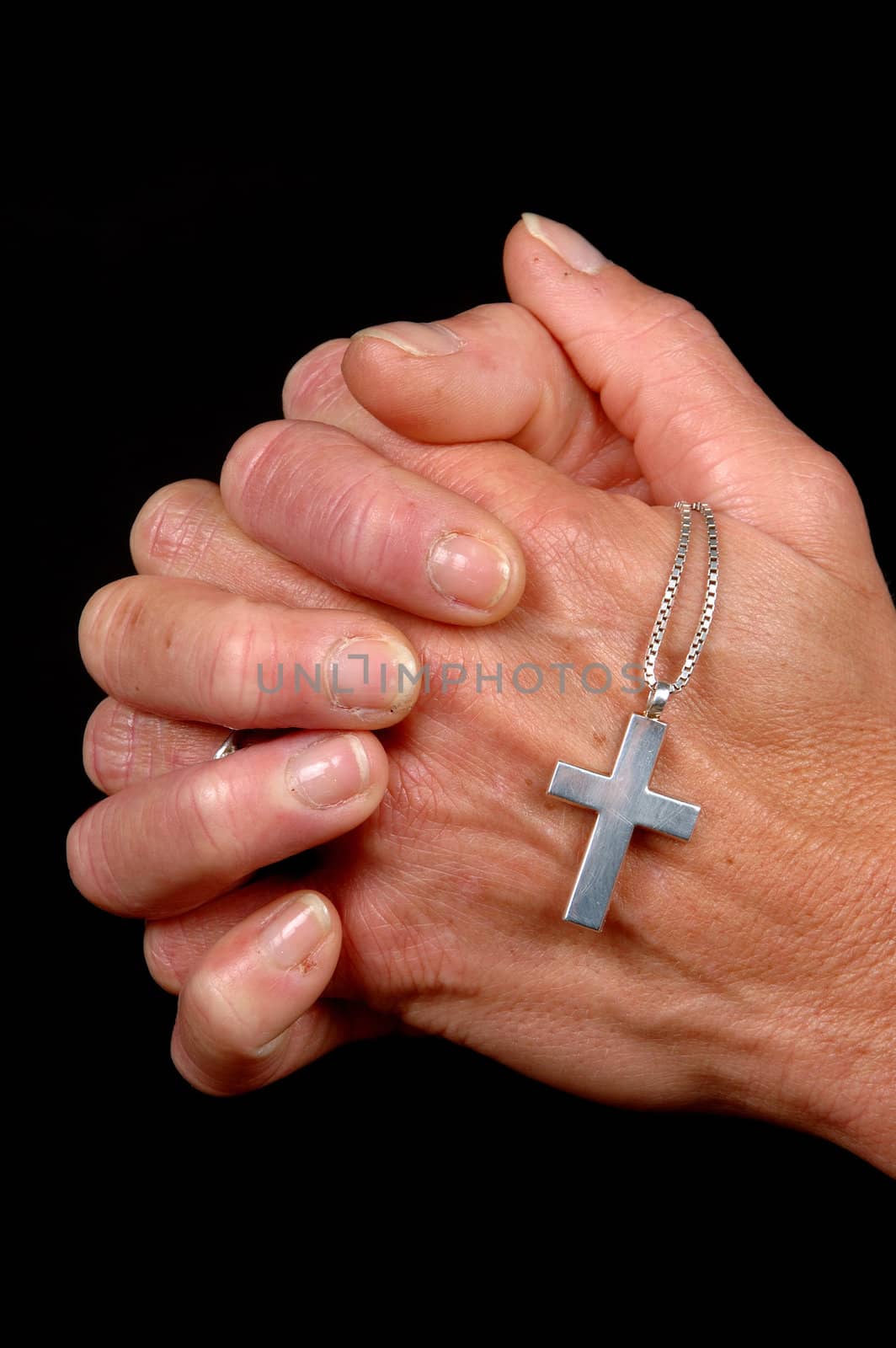 Woman is praying holding her cross. On black clean background.