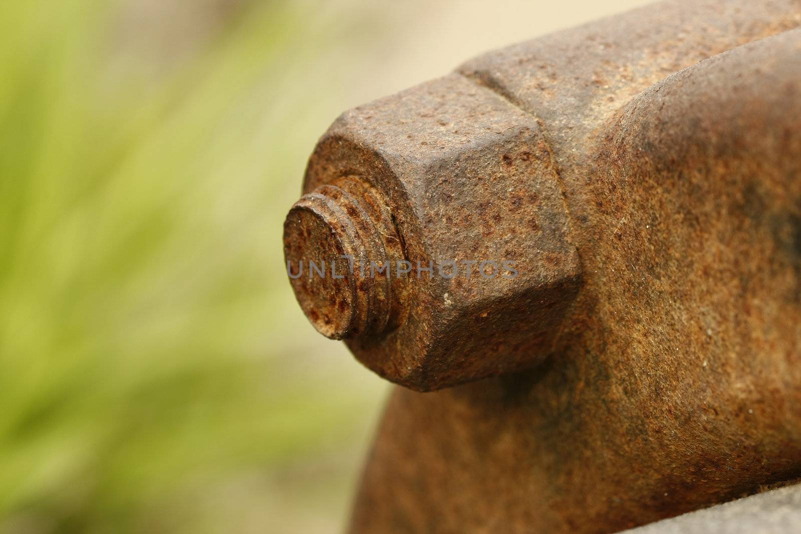 Rusted metal nut and bolt heavily corroded with nice green background.
