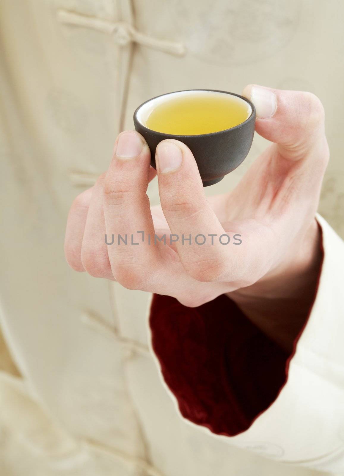 hand holding cup of green tea by dolgachov