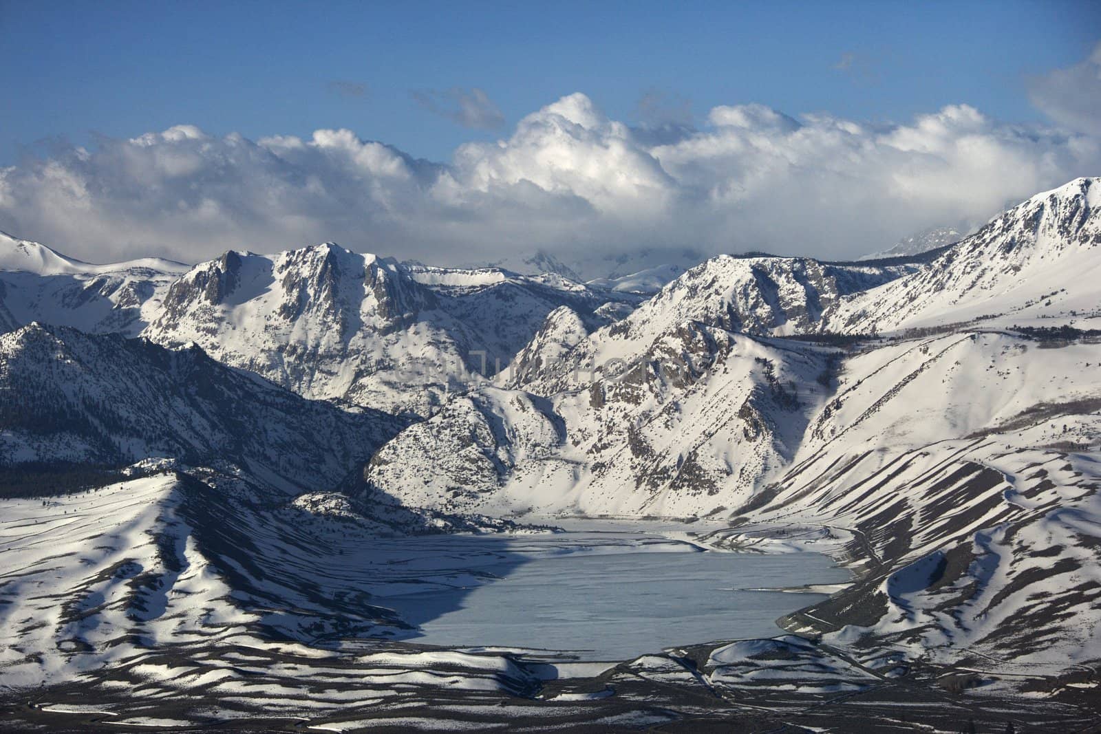 Aerial of snowy mountain landscape with frozen lake in Inyo National Forest, California, USA.